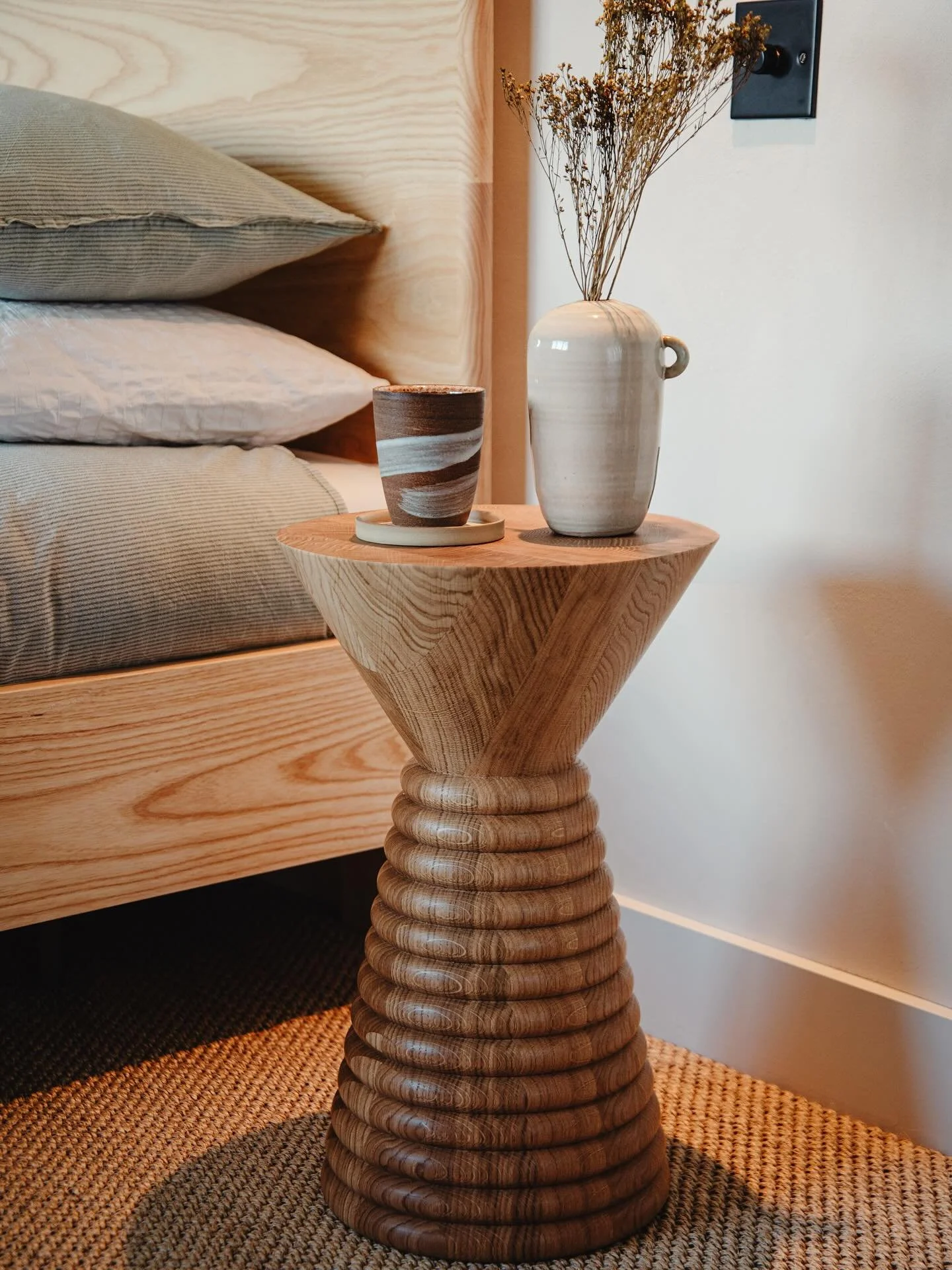 Hand turned Mia table in oak photographed next to our ash Super King Border Bed.