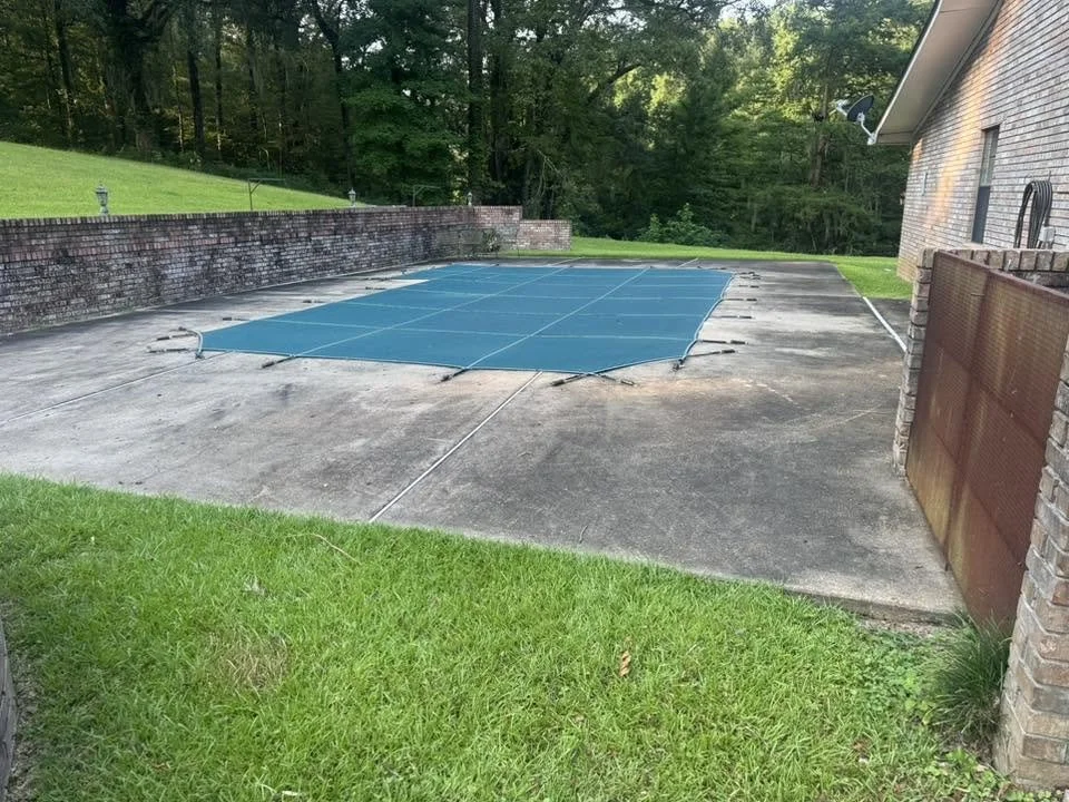 Before photo of a concrete pool deck before cleaning in Natchez, MS.