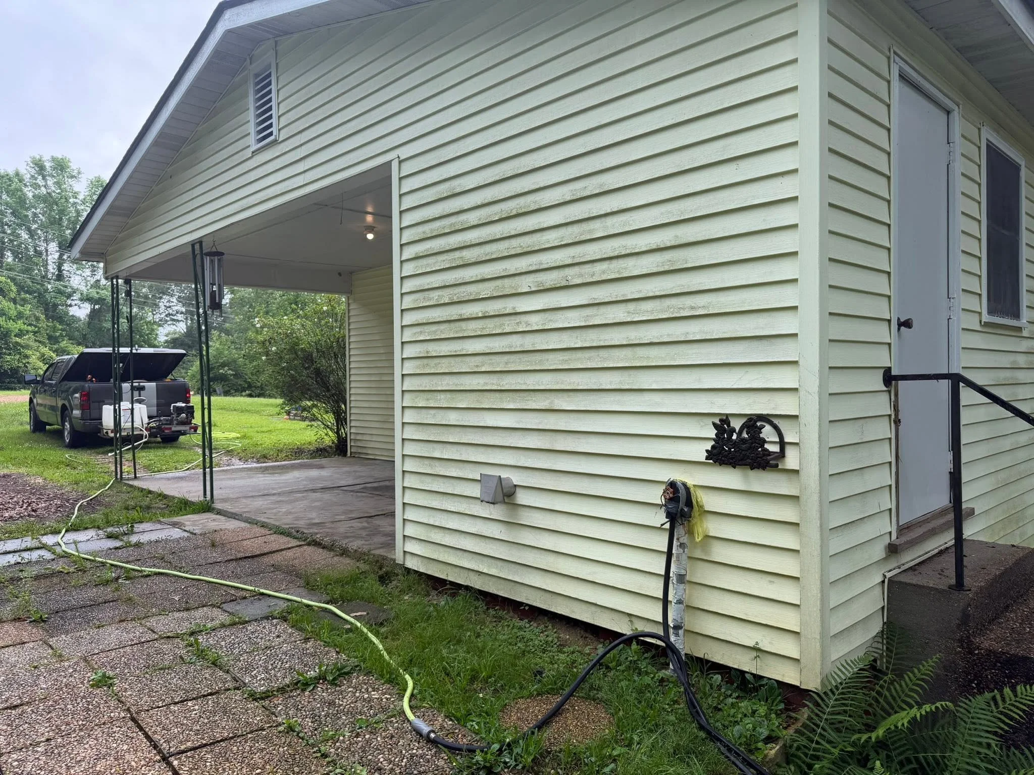 Vinyl siding and covered patio area before exterior cleaning.