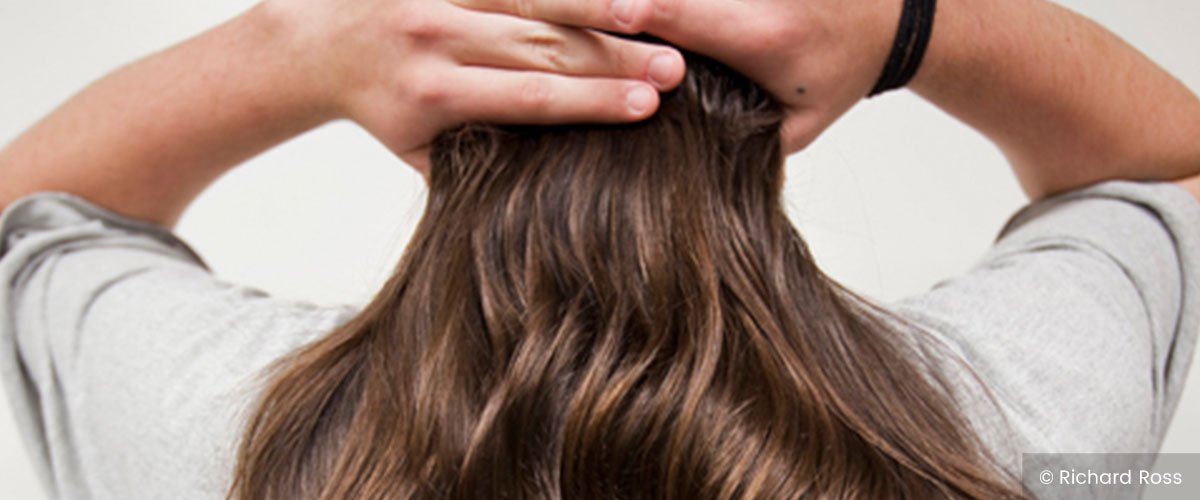 Man gathering long hair with hands, © Richard Ross