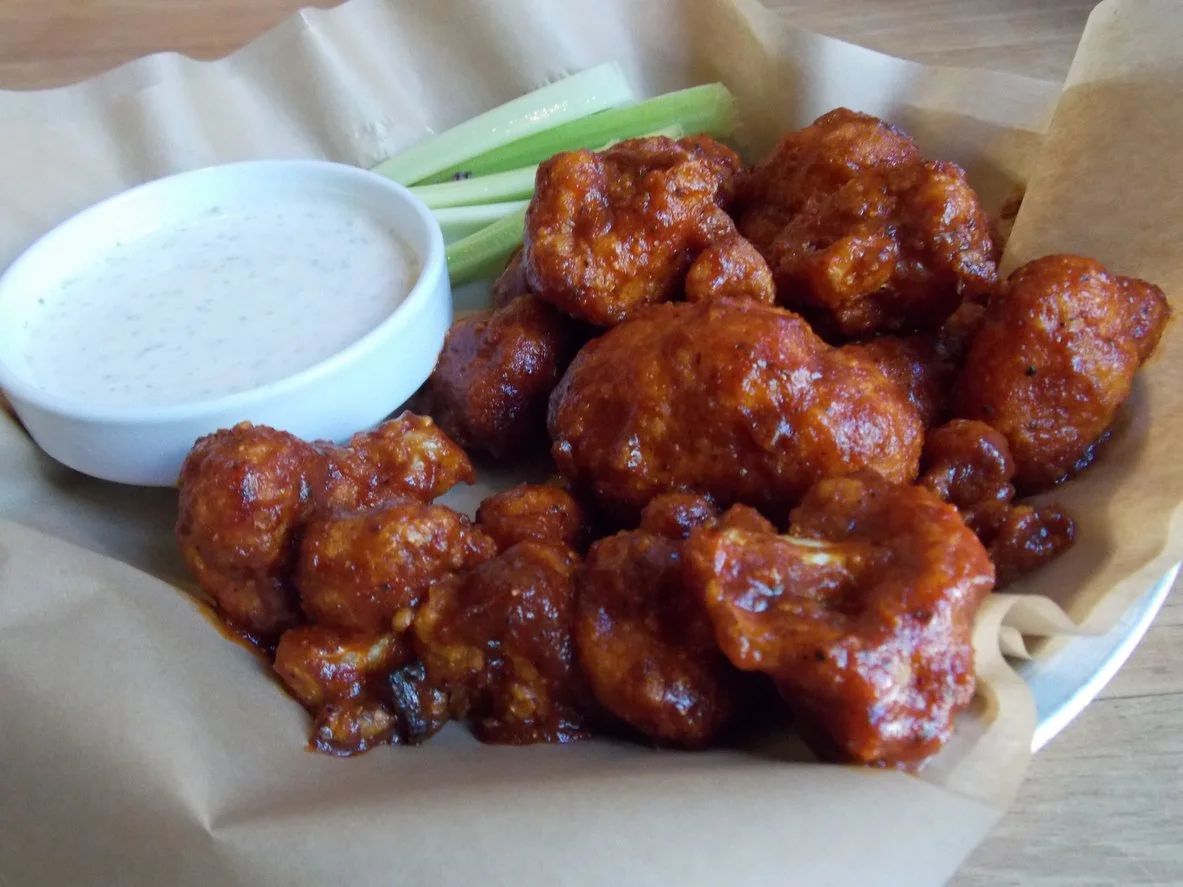 Cauliflower Buffalo wings with a bowl of white sauce