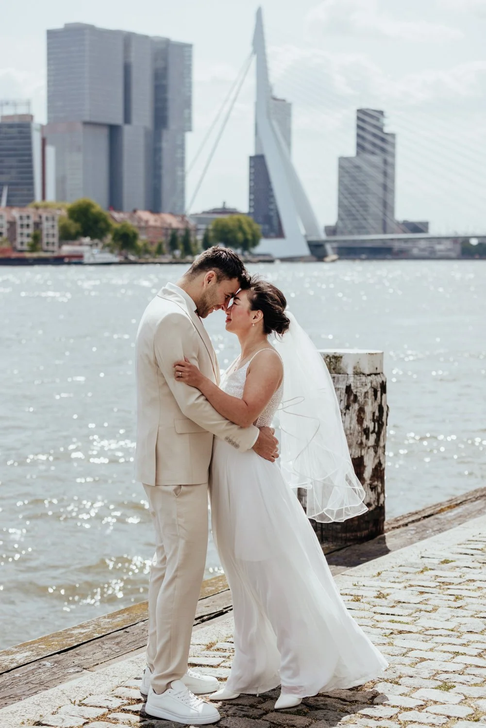 Bruidspaar tijdens de fotoshoot met de Erasmusbrug op de achtergrond