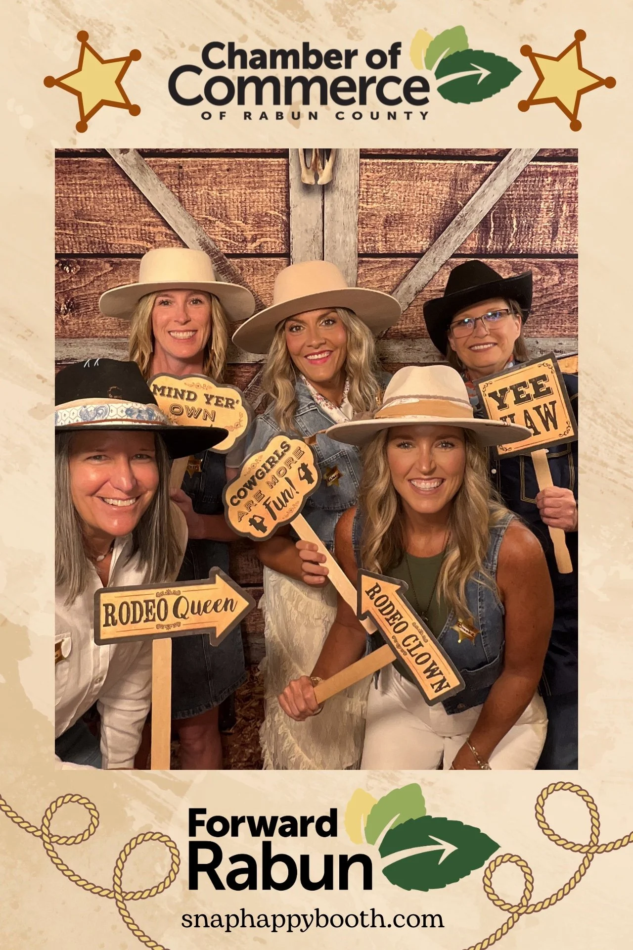 Guests dressed in Western attire posing in the Snap Happy Booth photo booth at the Rabun County Chamber of Commerce Hoe Down in Clayton, Georgia.