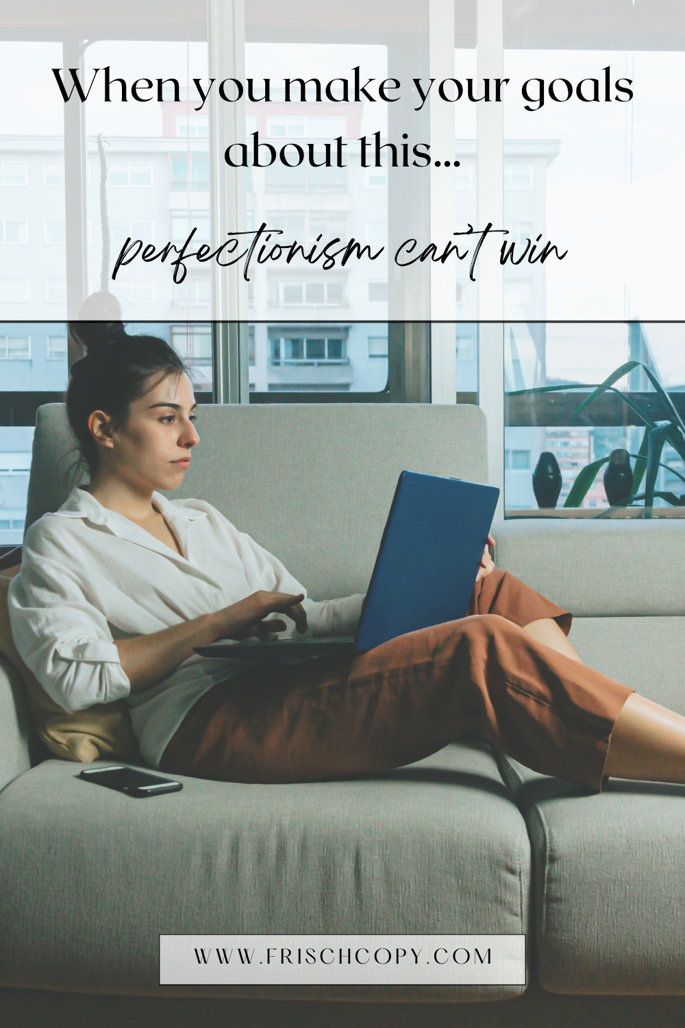 A woman is lounging on her couch working on her laptop