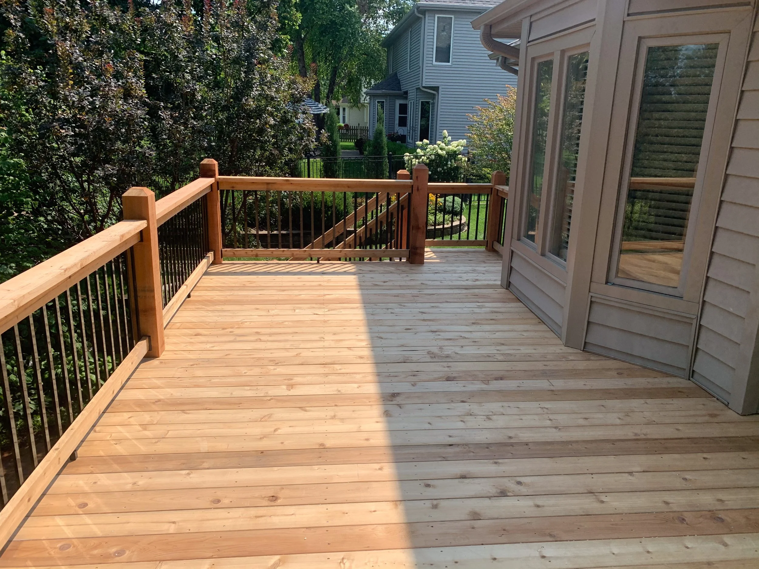 Cedar custom deck with black spindles in backyard of Papillion
