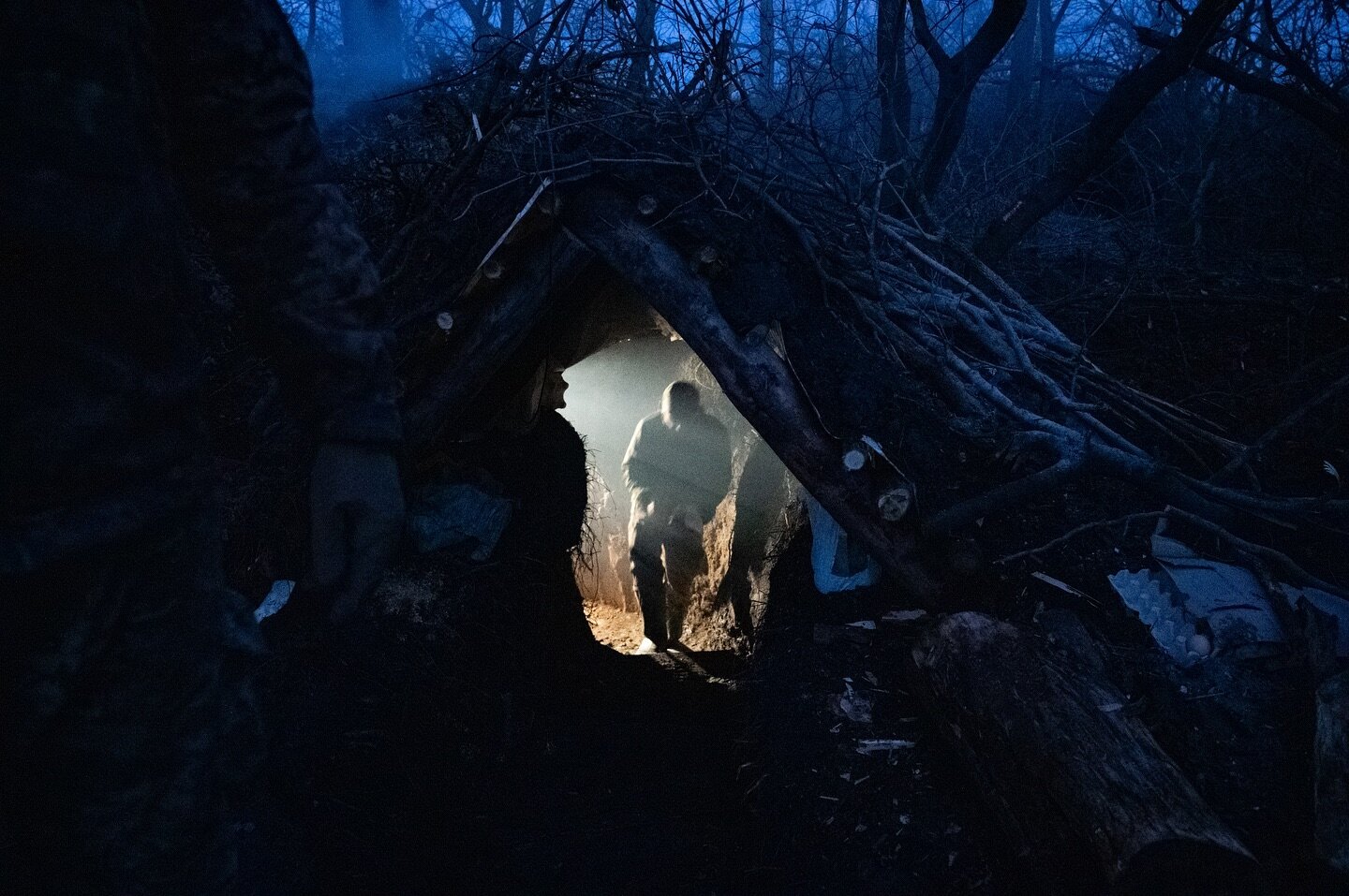 A Ukrainian soldier emerges from a bunker as darkness falls on frontline positions of the 21st Mechanized Brigade in Donetsk Oblast, Ukraine, 28 December 2023.