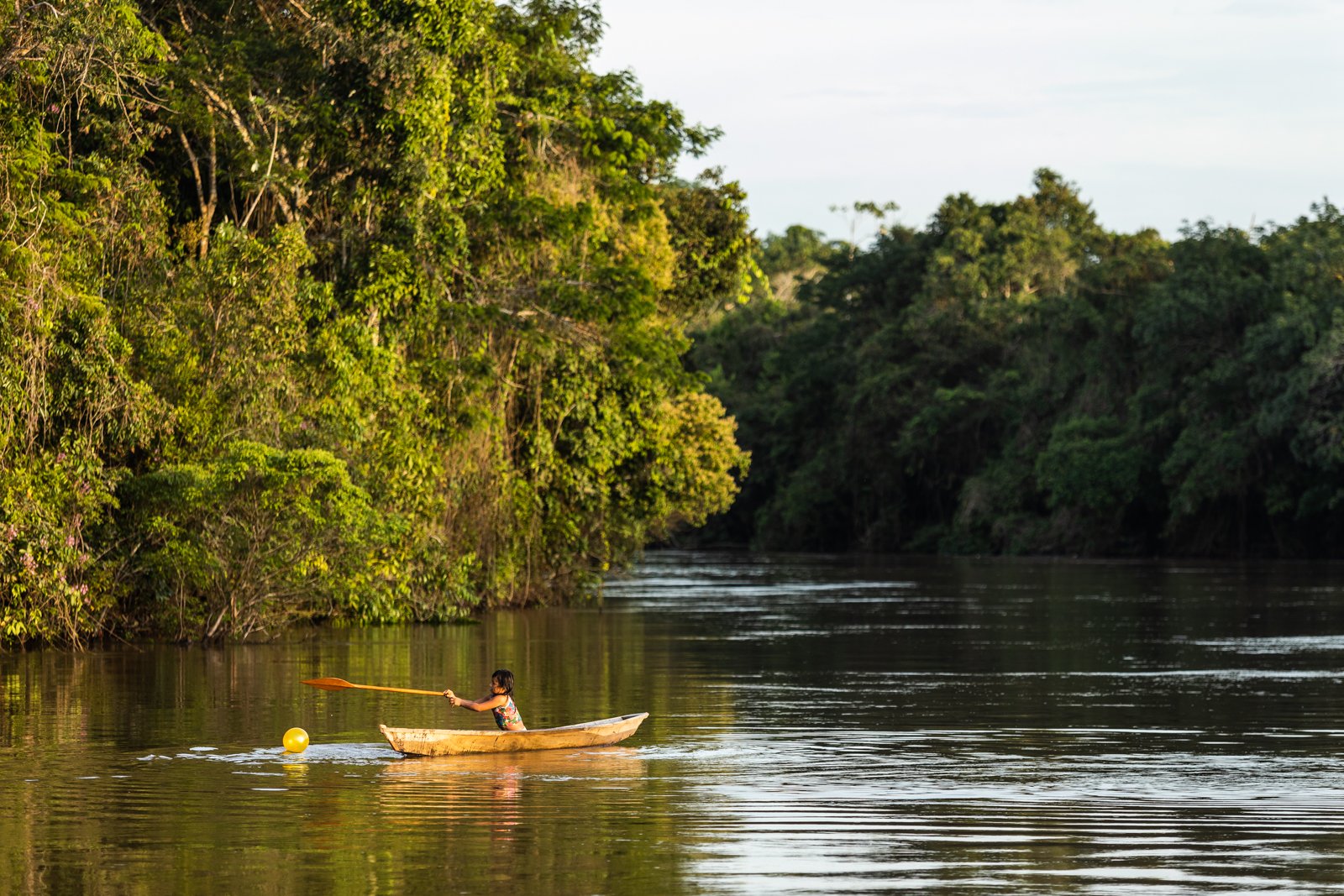 Playtime looks different for children of the Amazon Rainforest. Chasing down a runaway ball on a powerful river takes a familiarity with water that begins as soon as kids can walk. With canoes, as soon as they can hold their own paddle. This young g