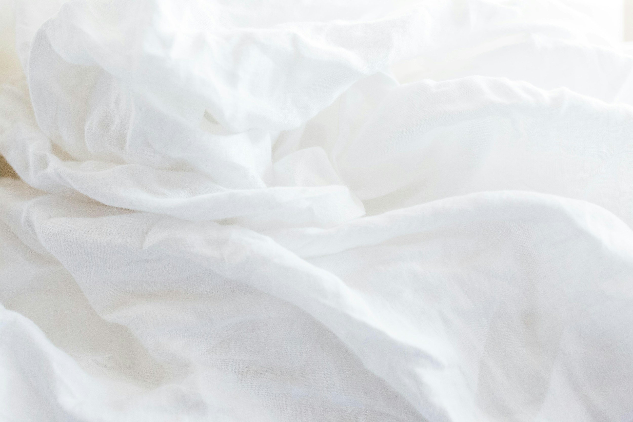 Fresh white bed linen in a sunlit guest bedroom