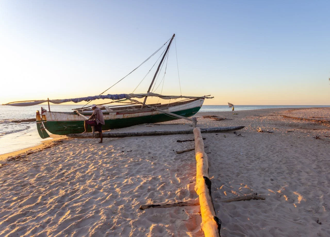 Pirogue traditionnelle sur une plage de Madagascar au coucher du soleil