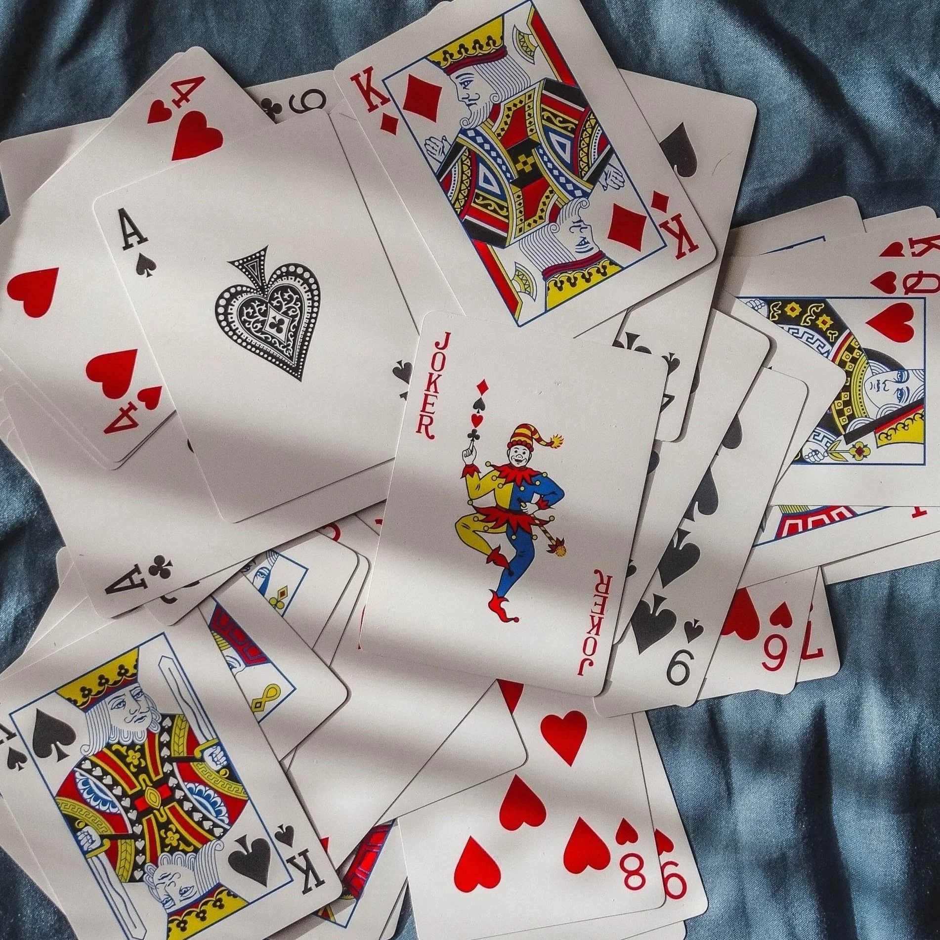 Scattered pile of playing cards with a joker in the middle