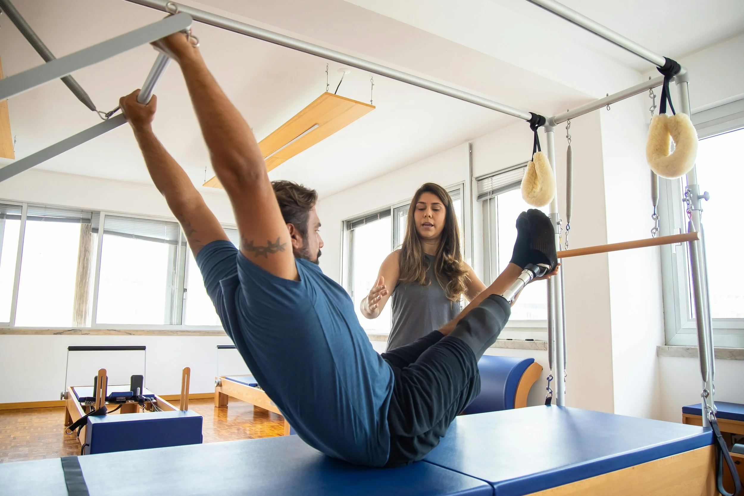 persona con disabilità alla gamba che fa riabilitazione su pilates cadillac