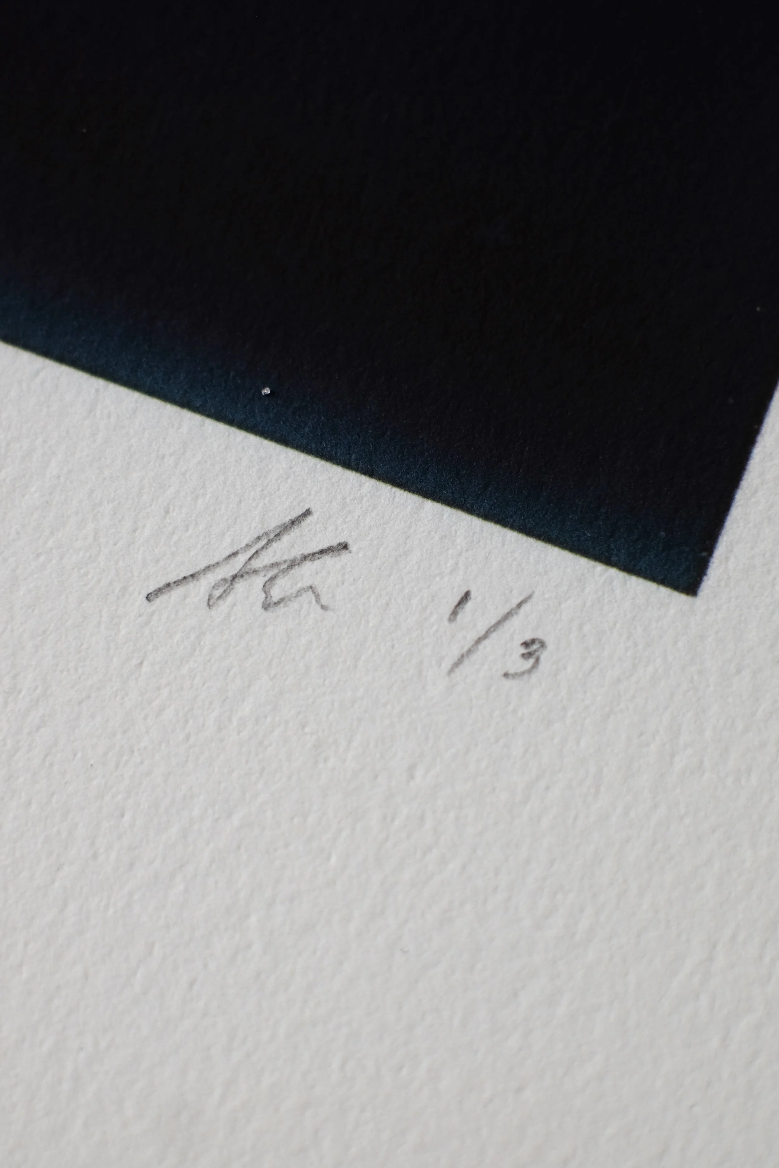 Close-up of an art print with a signature and edition number '1/3' written in pencil beneath the artwork.