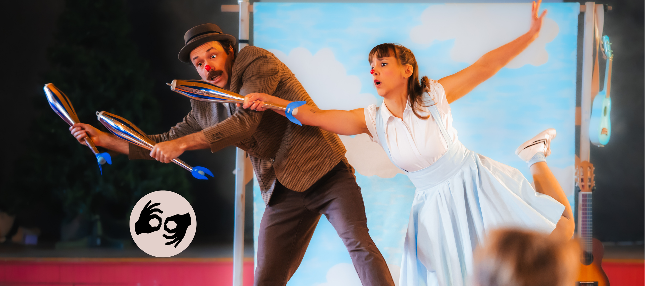 two clown-y jugglers perform in front of an audience of children
