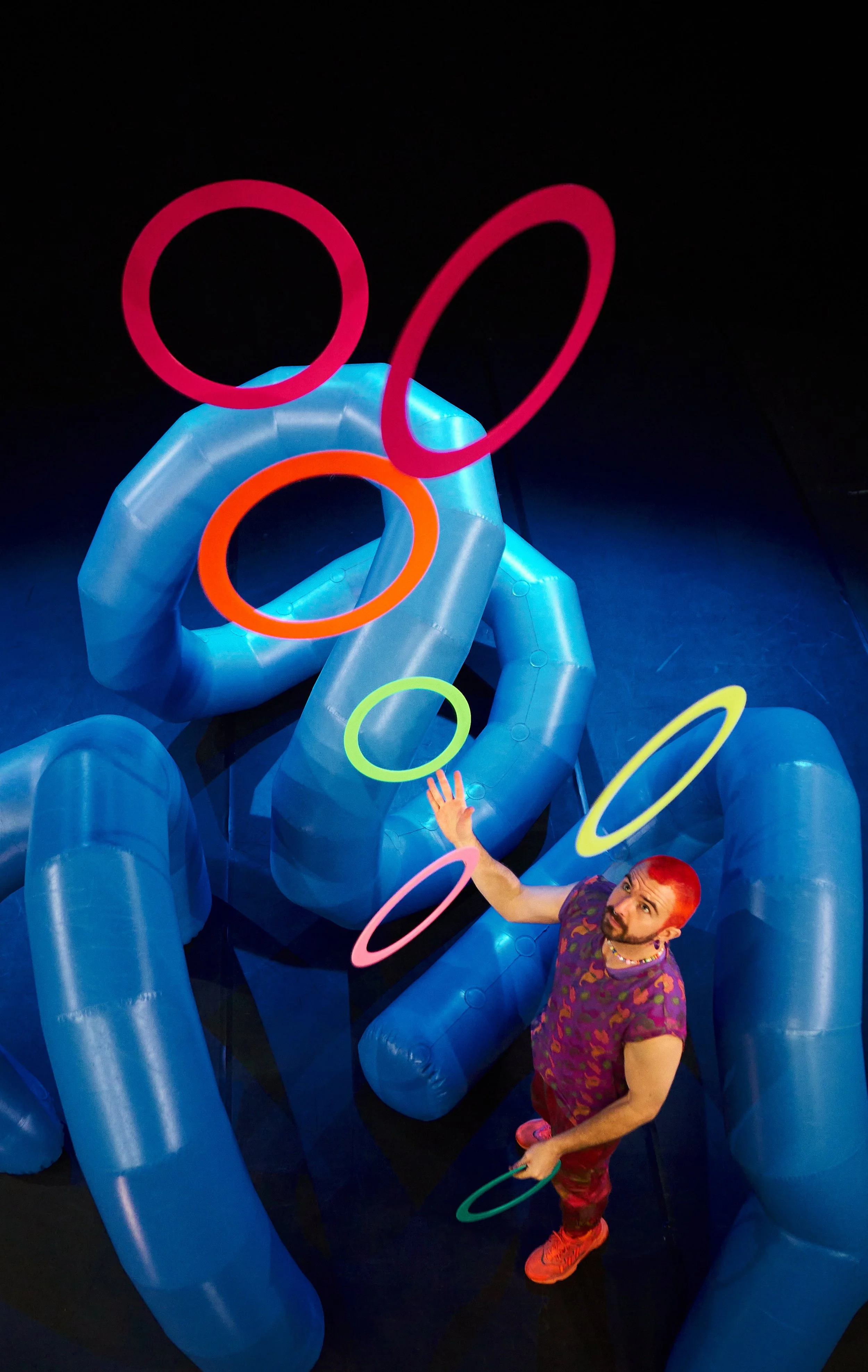 image of Wes Peden juggling 5 colorful rings