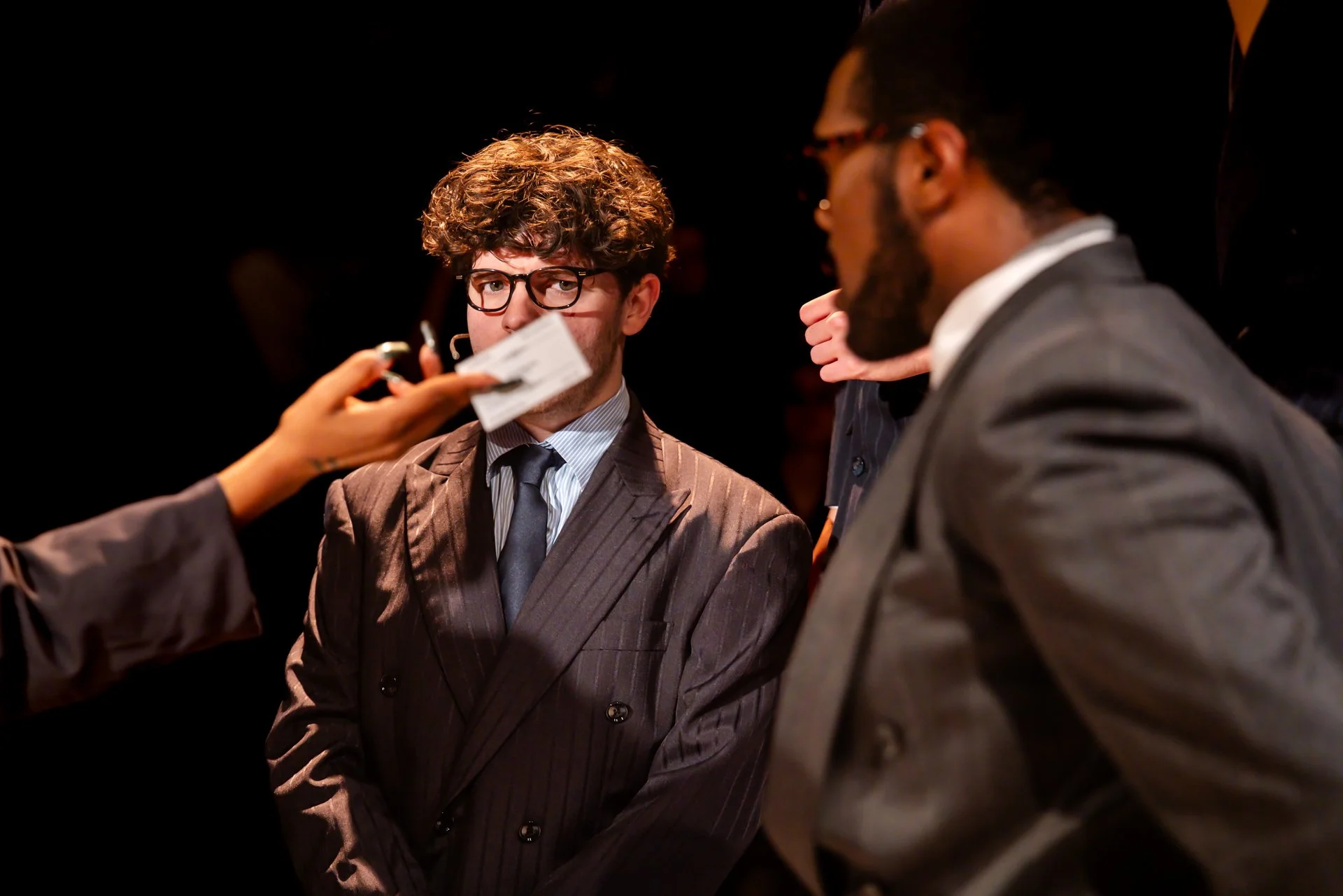 Two businessmen in suits trading business cards in American Psycho at Shenandoah Conservatory