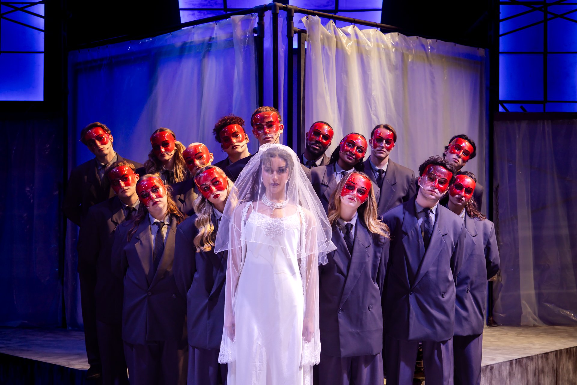 Ensemble of Patricks in gray suits and red masks surrounding a bride in white in American Psycho at Shenandoah Conservatory
