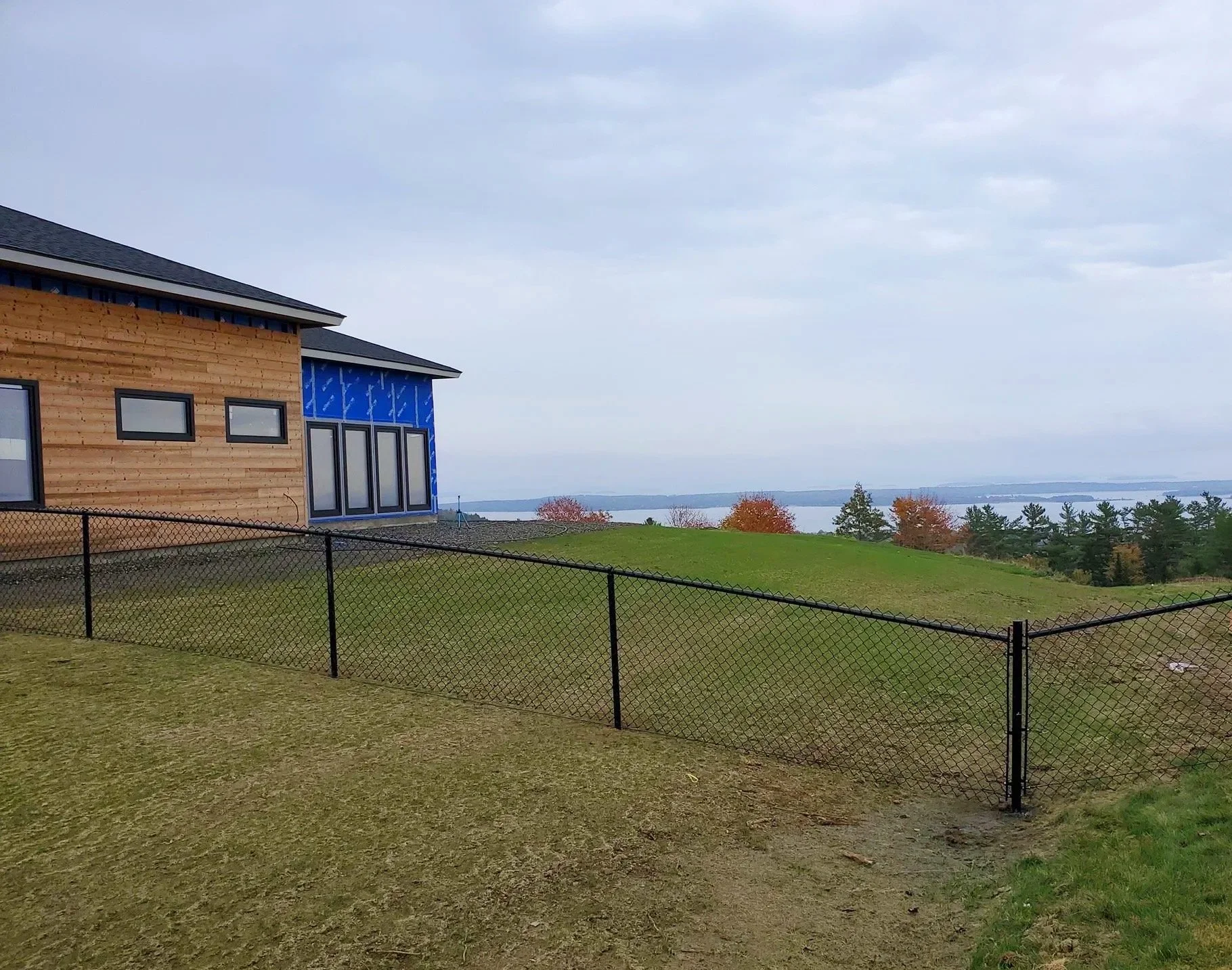 4' tall black chain link fence backyard enclosure for new home with Bayview in background