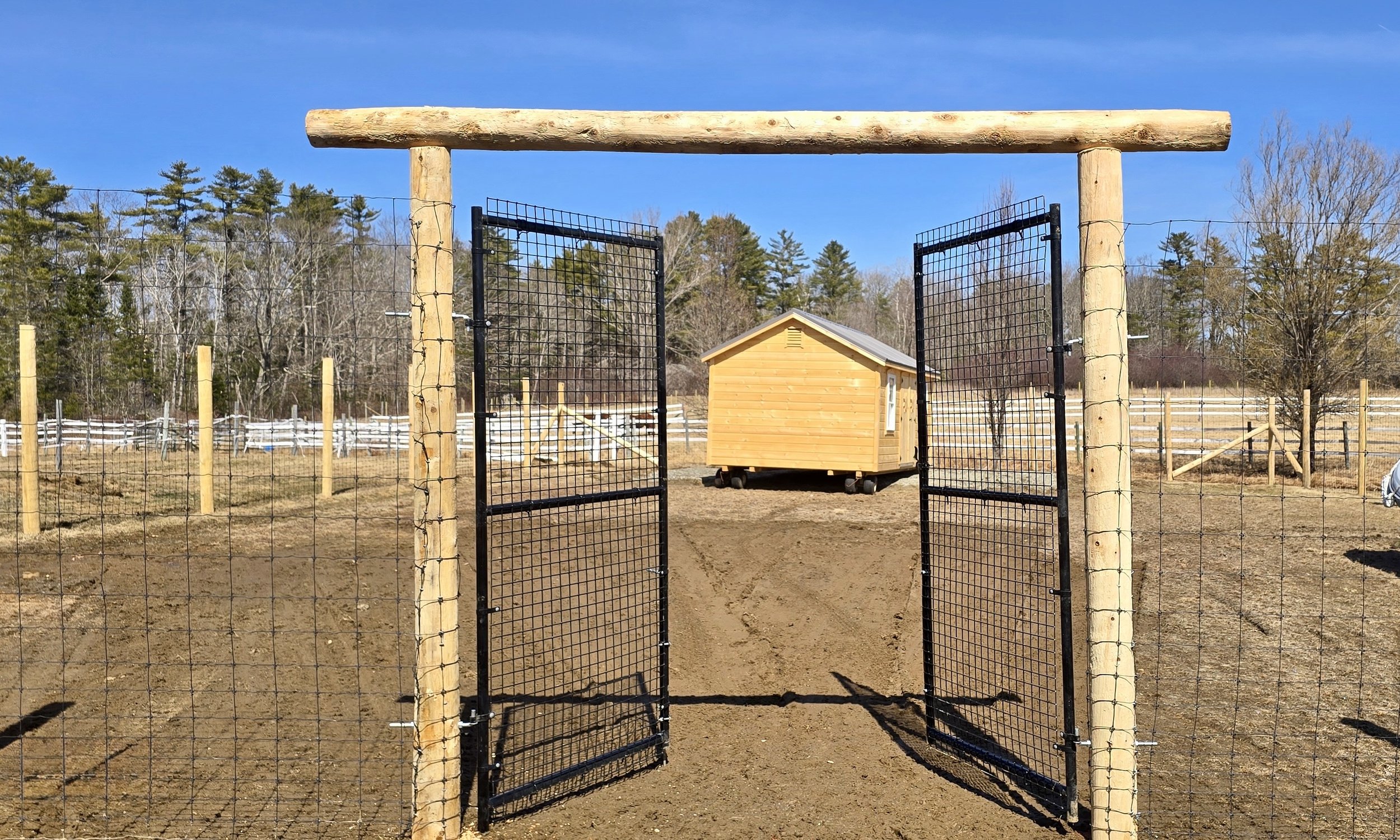 round cedar post arbor corral entry with deer fence and ag gates