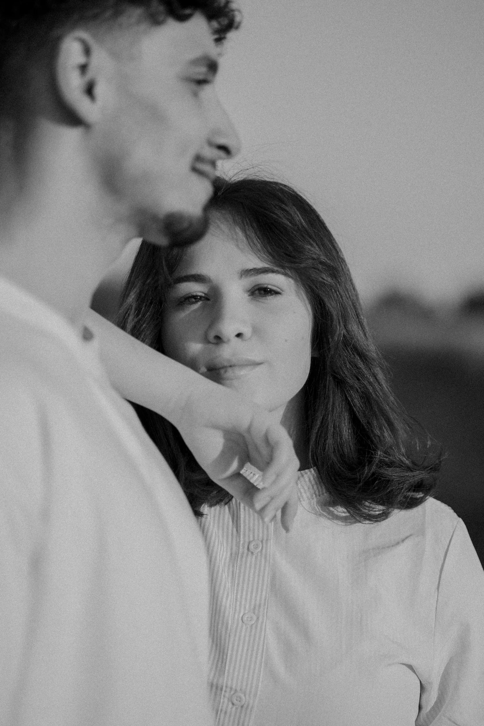 Black and white image of a couple standing close together and smiling, representing connection and healthy communication in relationships