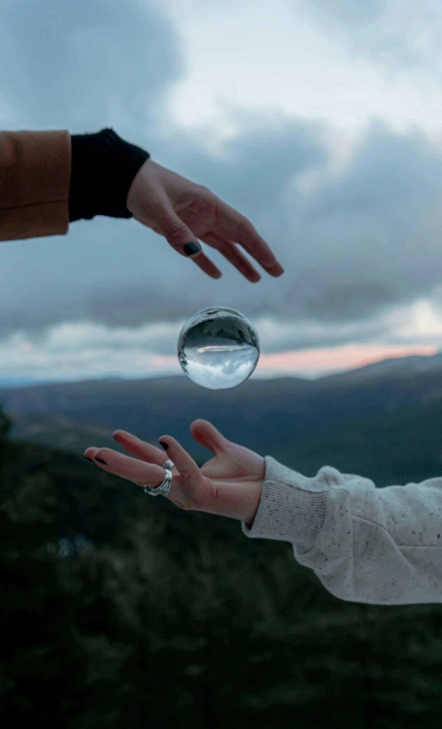 Two people passing a clear ball between them, representing mutual engagement and healthy relationship dynamics.