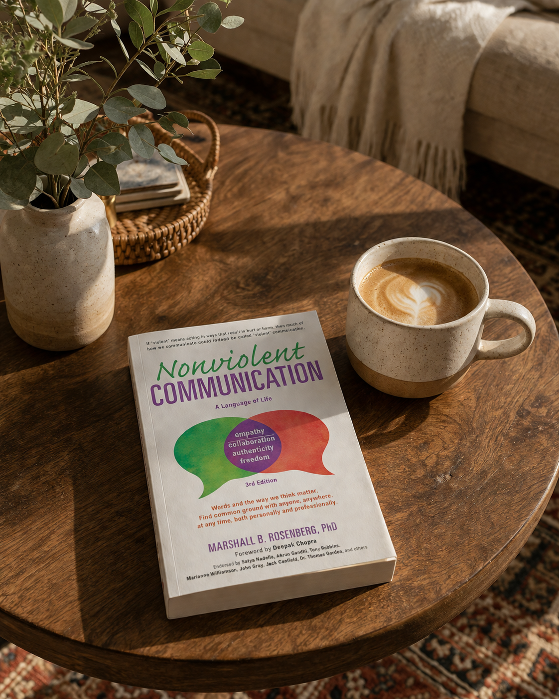 Nonviolent Communication book on a cozy table with coffee and plant, representing a reflective moment for exploring communication, feelings, and boundaries in relationships