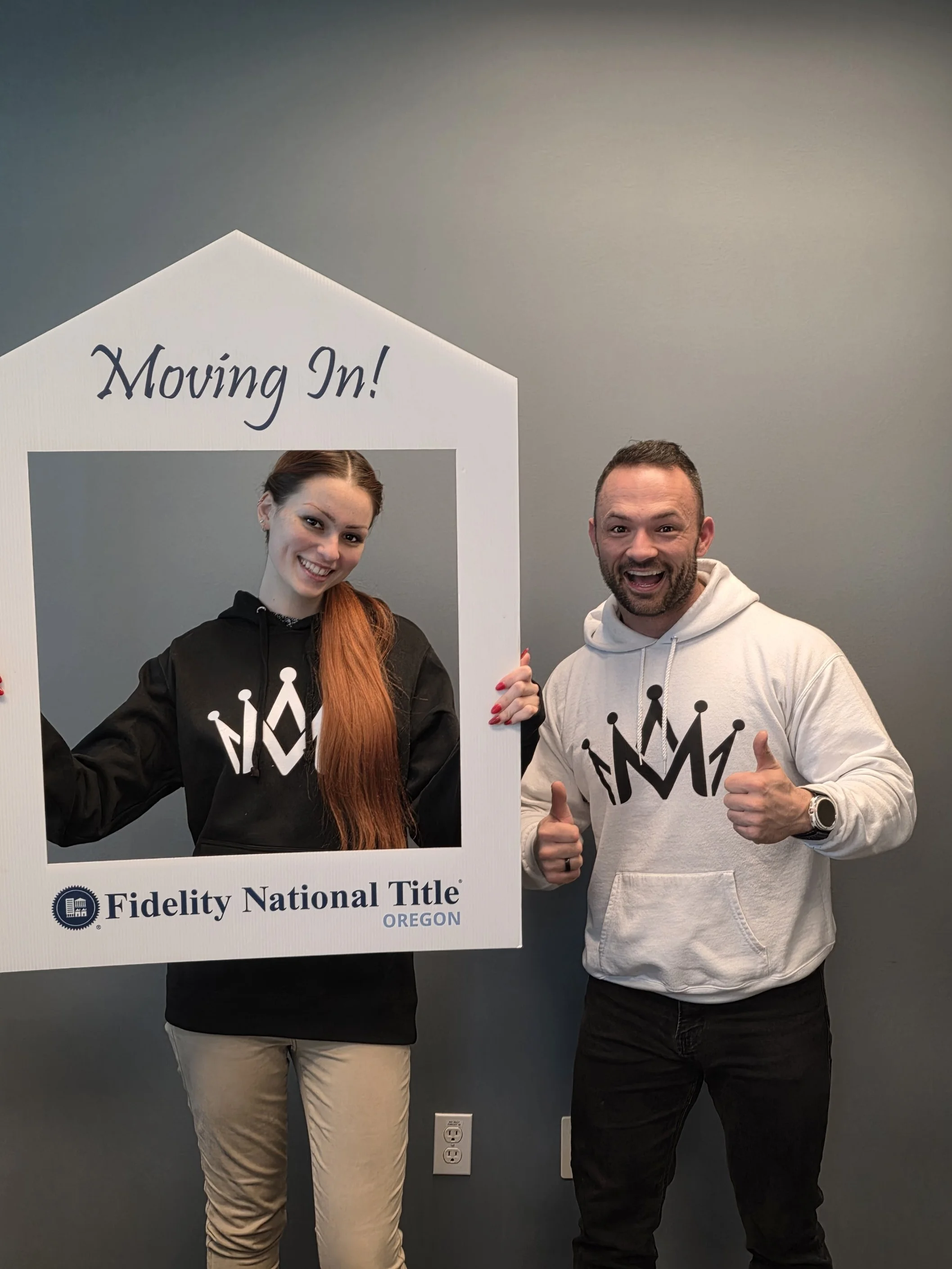 Mike Maddux celebrating a home purchase closing with a happy client wearing Maddux Mortgage apparel.