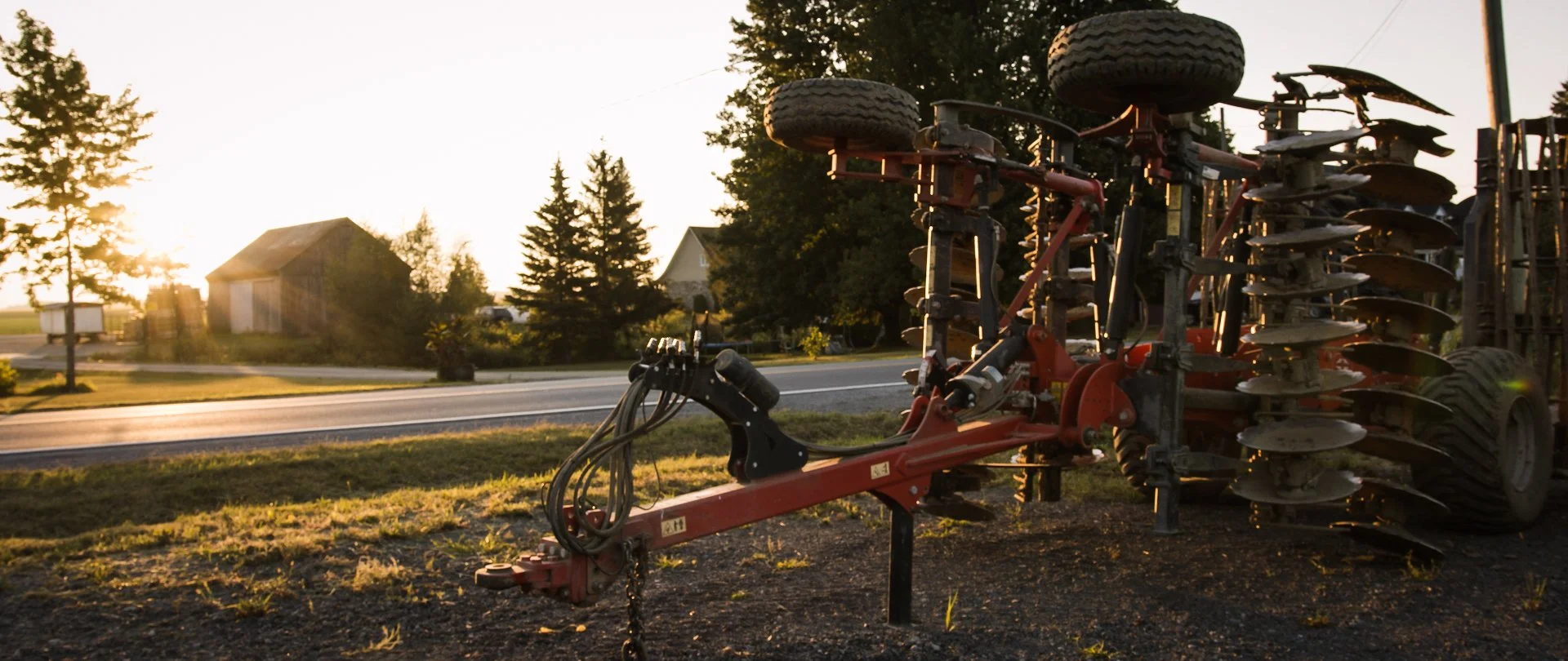 Farm equipment parked at sunrise on a small family farm preparing for specialty crop production