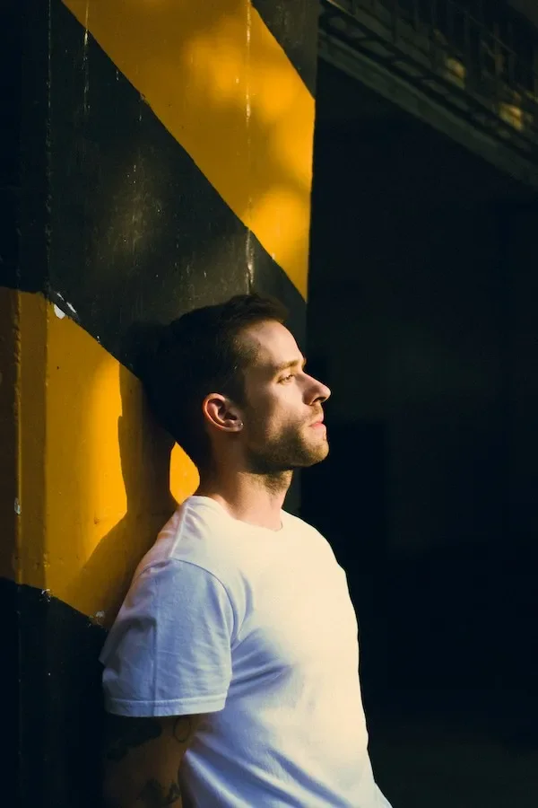 A man looking away with a yellow and black background
