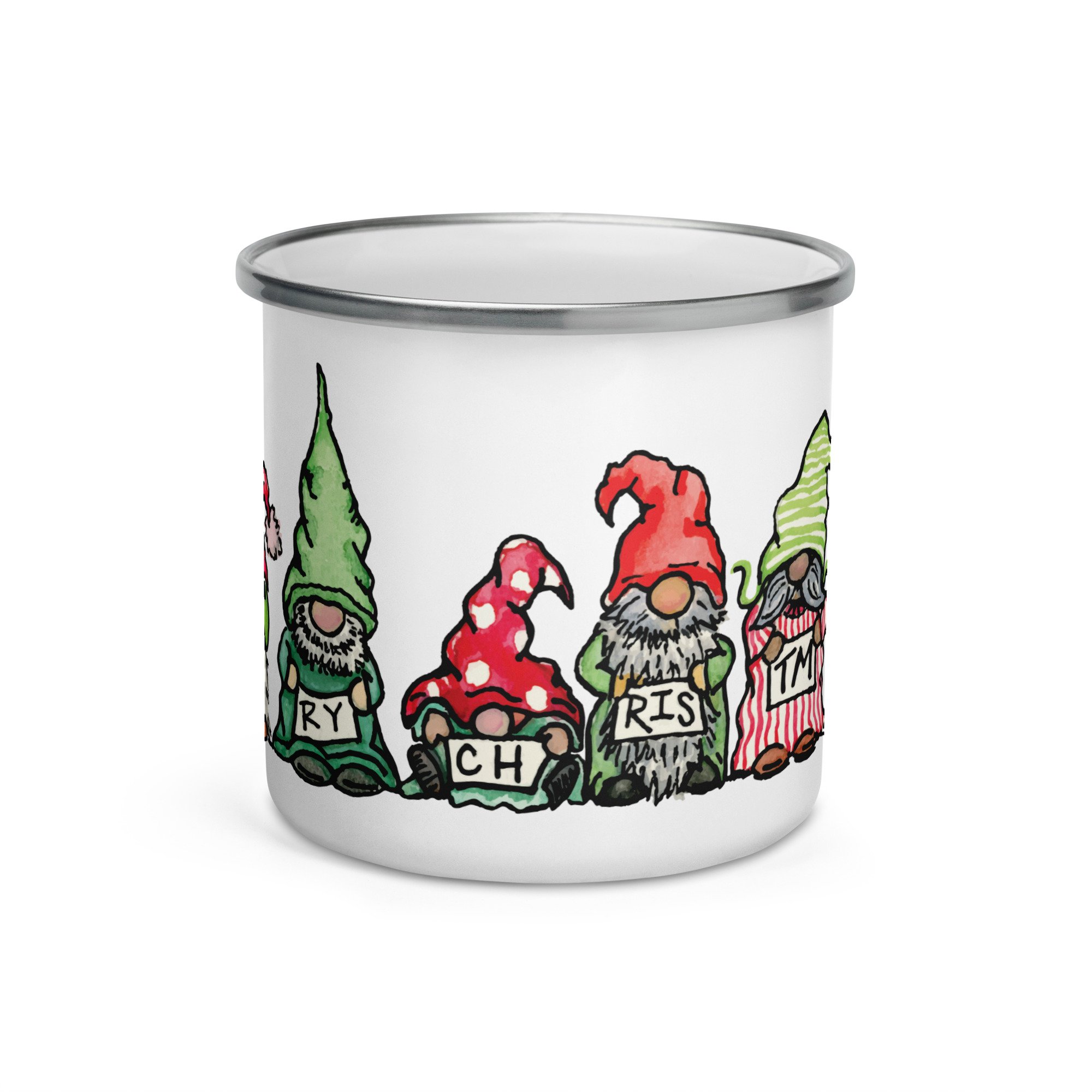 A white paper cup decorated with colorful illustrations of gnomes, trees, and mushrooms, featuring the words "Merry Christmas."