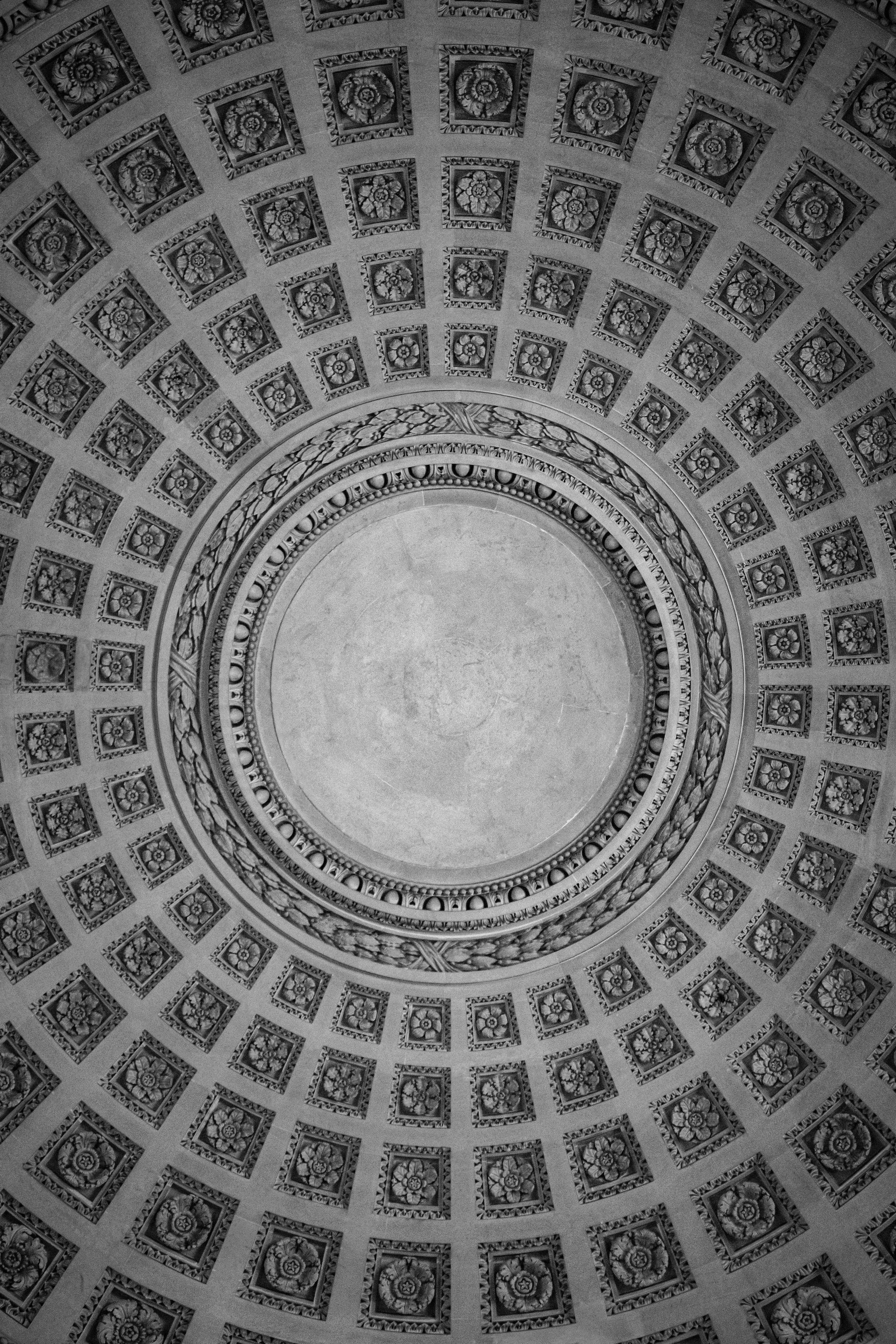 View of a decorative, ornate circular ceiling with detailed, patterned coffered squares and concentric rings of intricate designs.