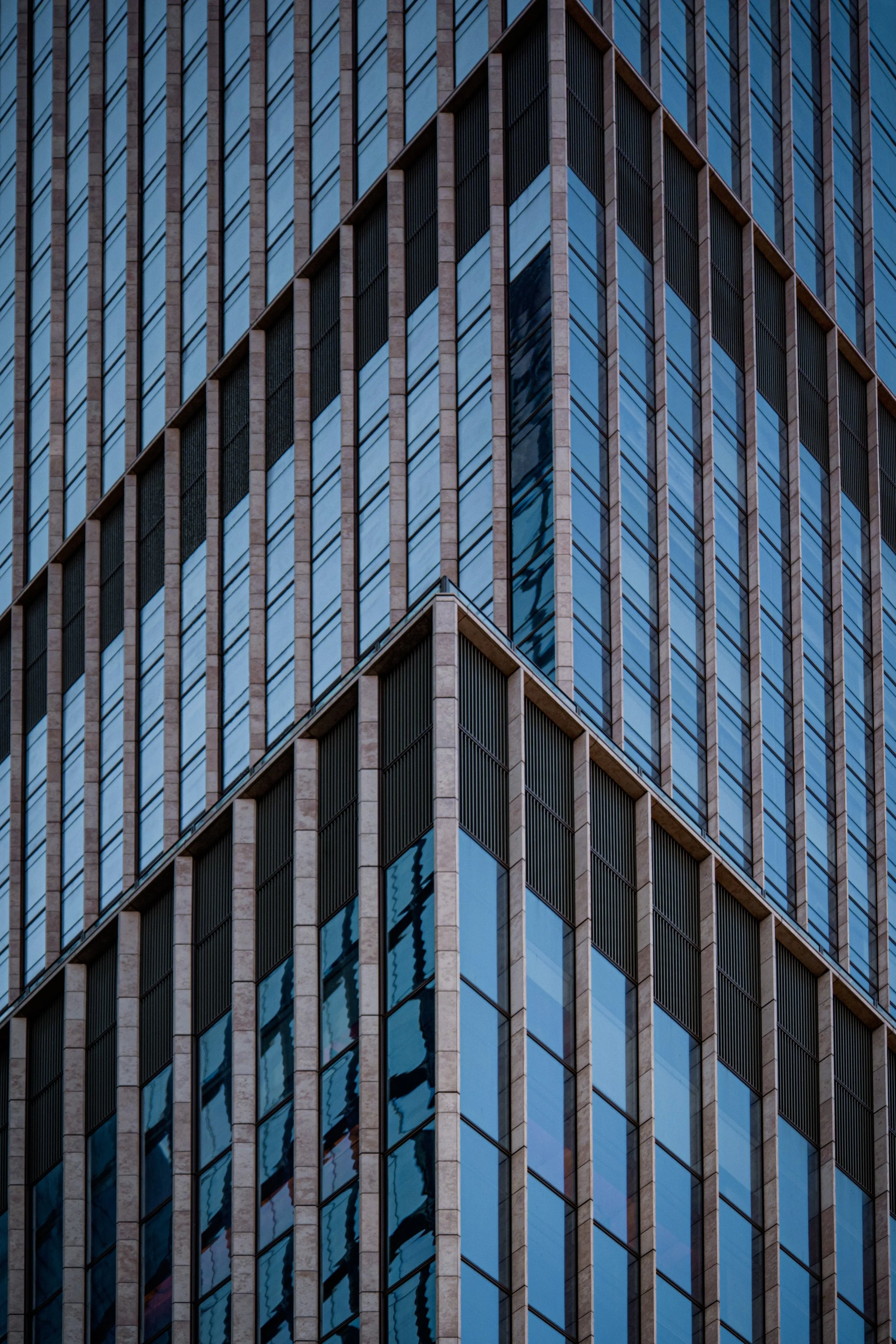 Close-up of a modern glass and metal office building with reflective windows.
