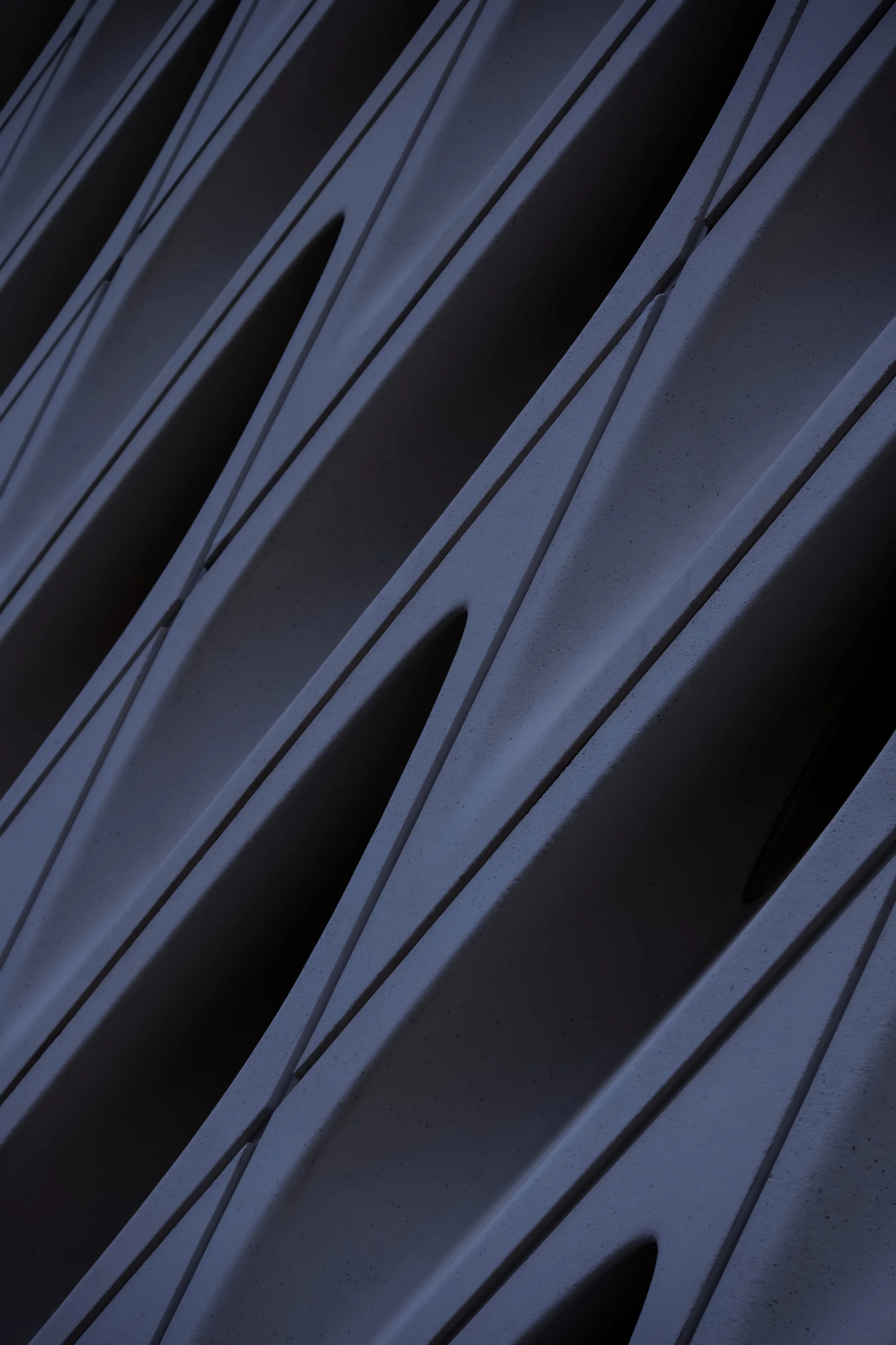 Close-up view of multiple grey metallic lockers or storage units with rounded vents on the doors, arranged in a row.