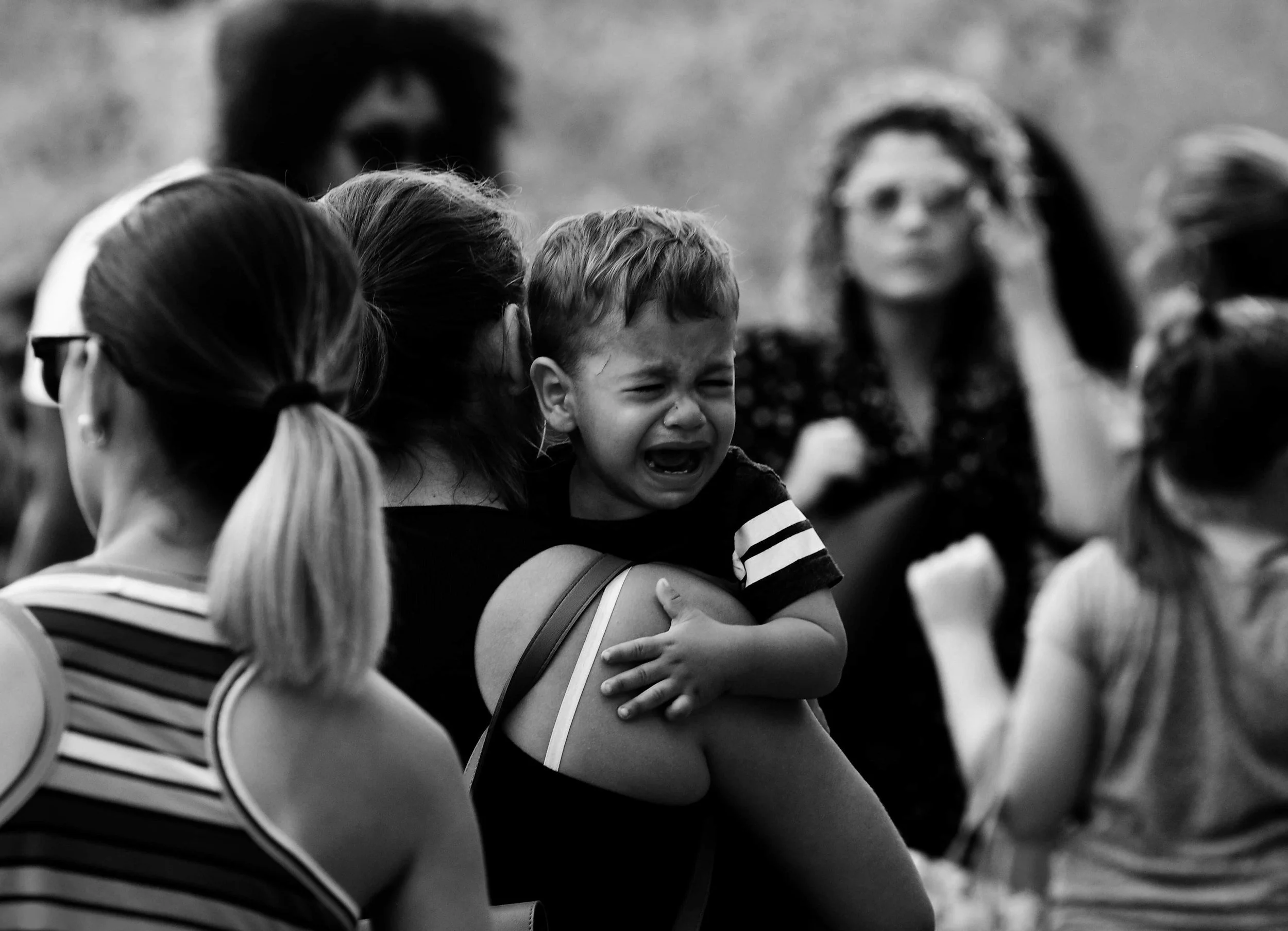 black and white picture of mother carrying crying child