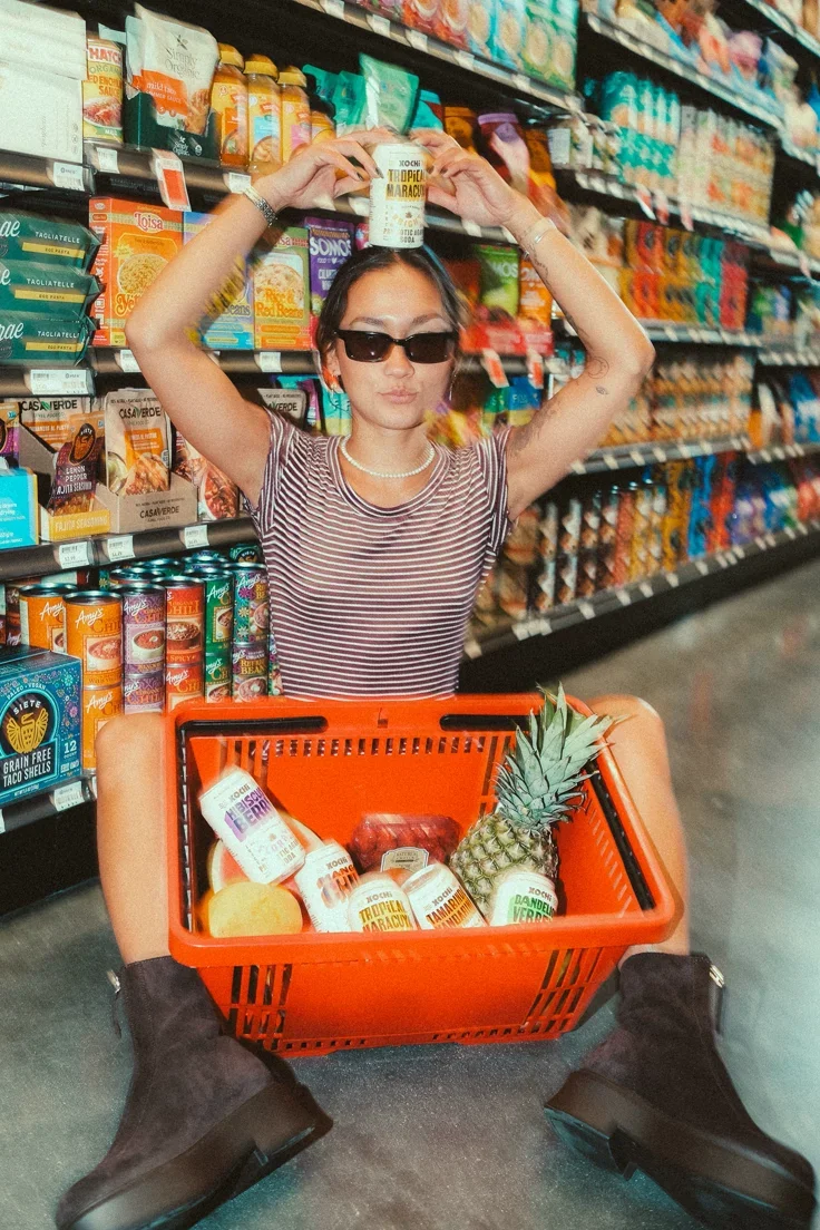 Woman shopping in grocery store aisle with basket — Neighbours Provisions Tofino