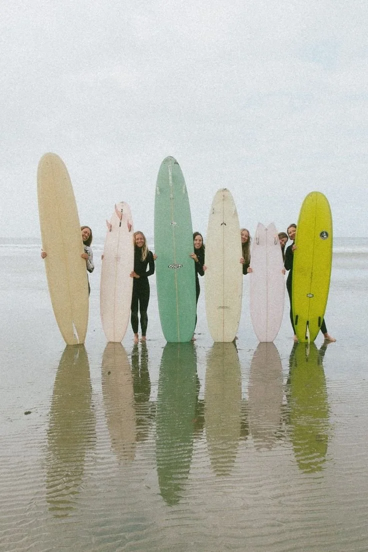 Group of surfers with colourful surfboards on Tofino beach