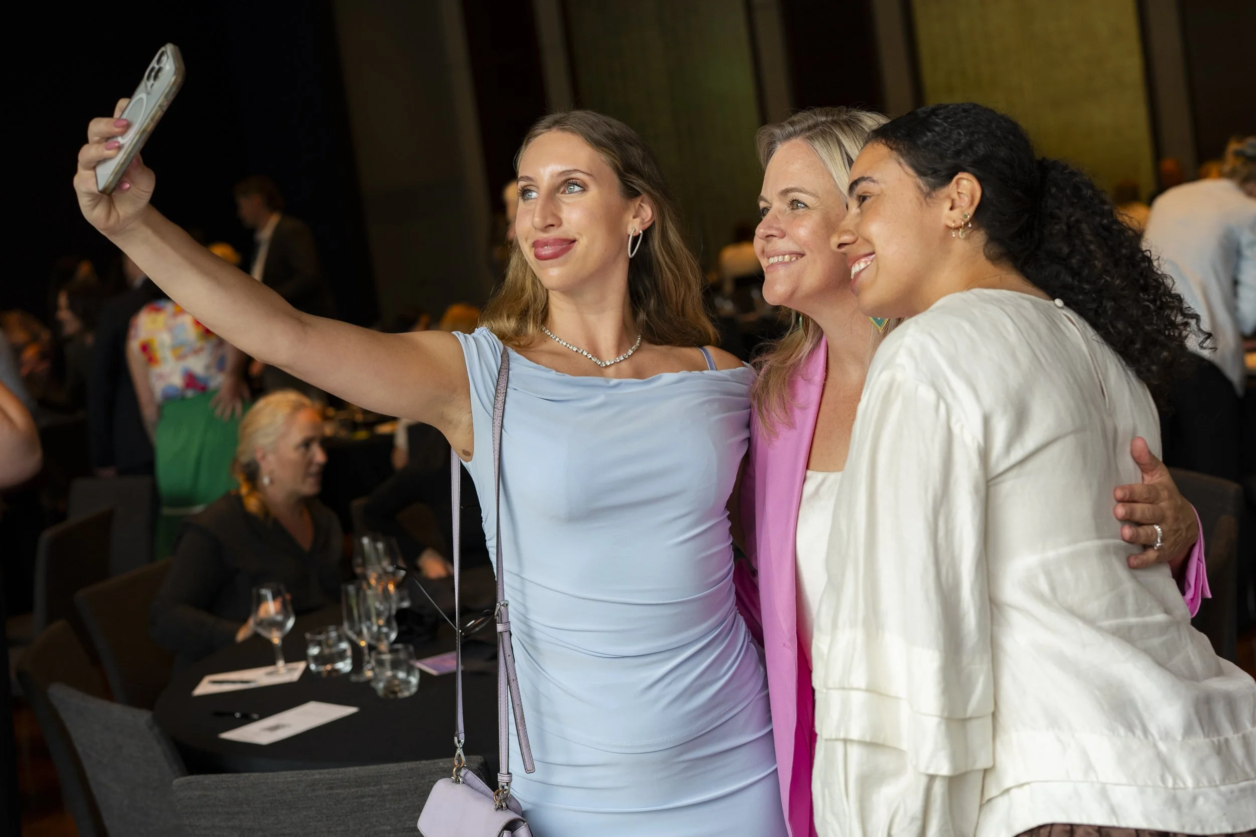 Three women taking a selfie together at a corporate awards evening