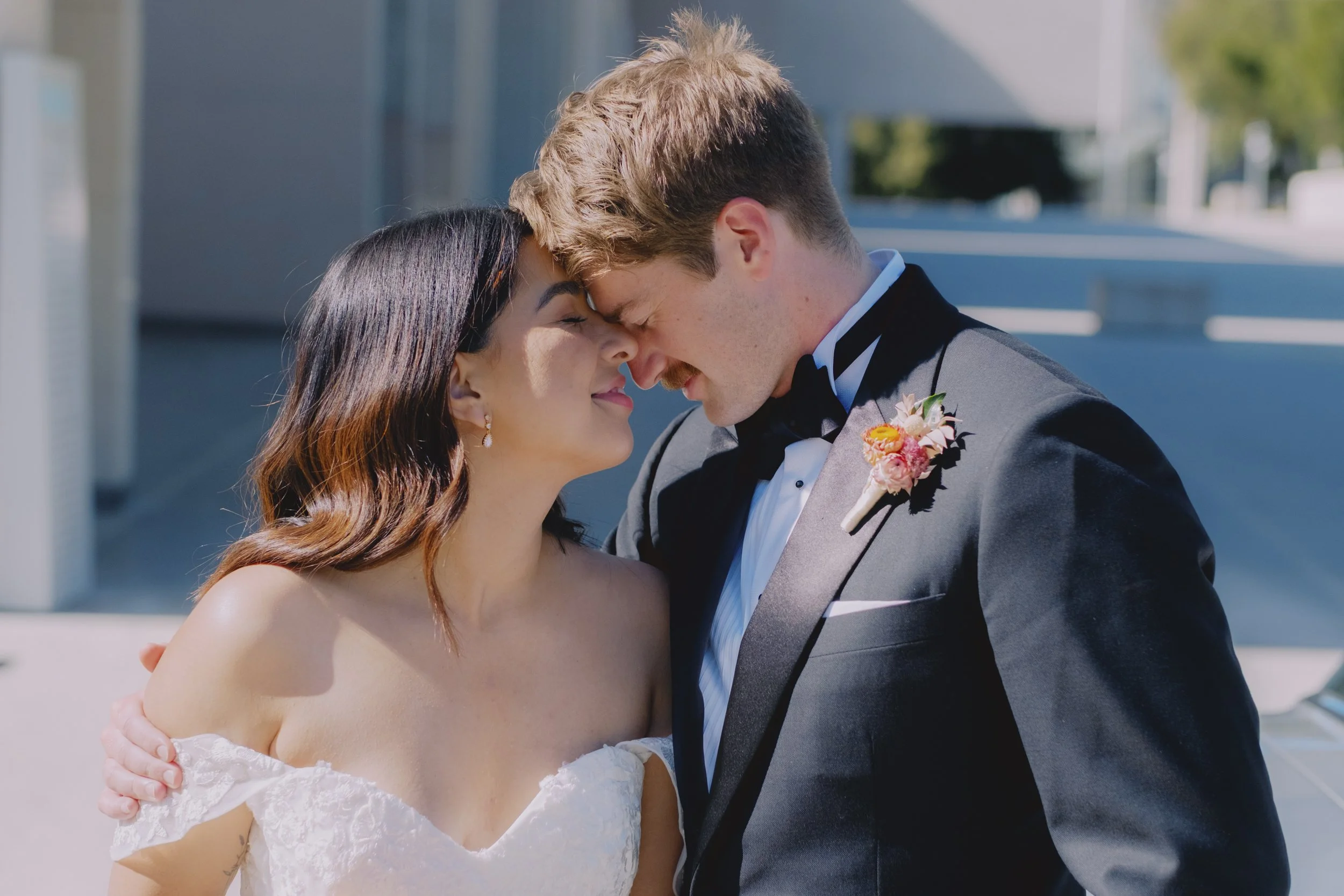 Bride and groom with foreheads touching in an intimate moment, shot outside the National Gallery of Australia, Canberra