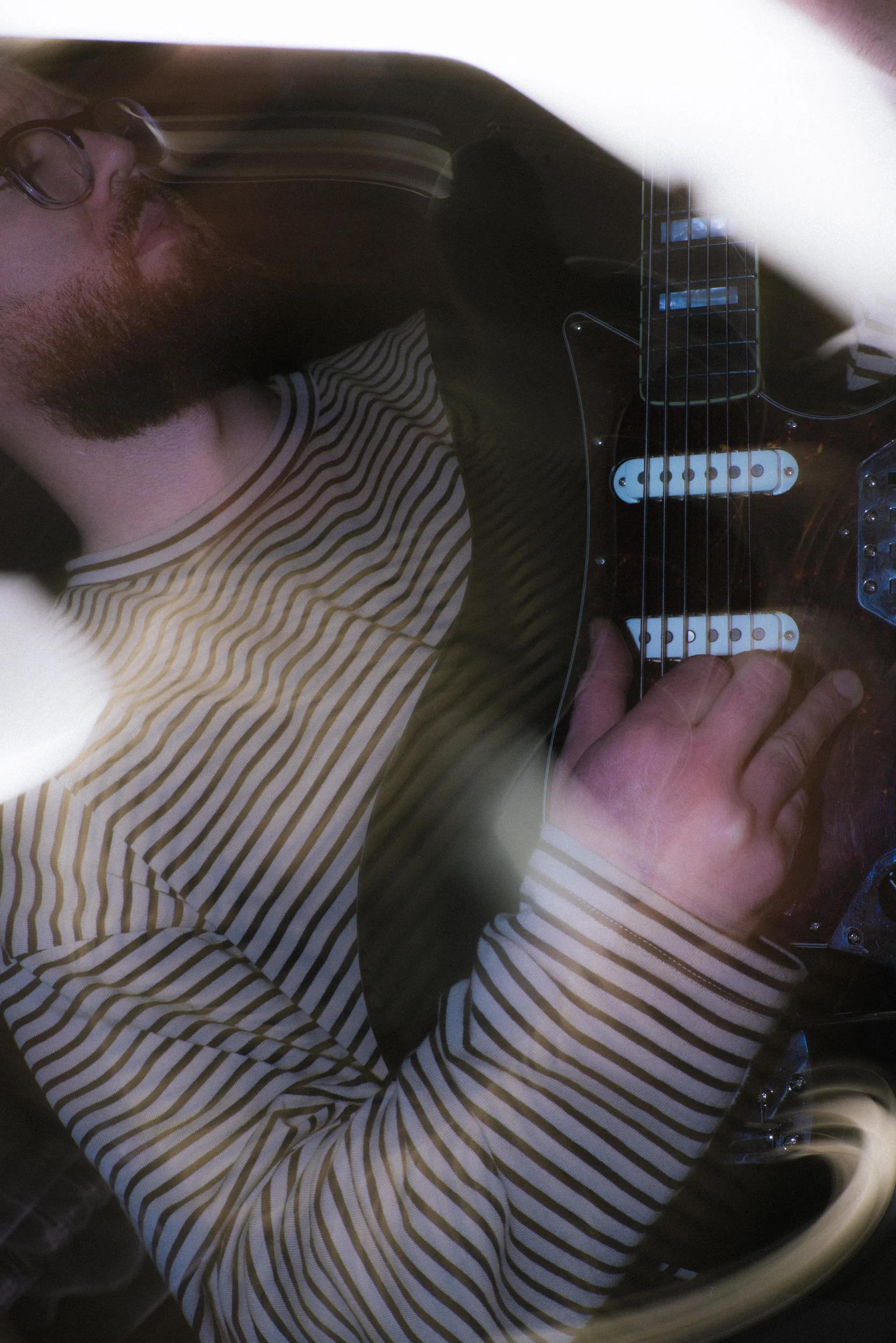 Abstract musician portrait with guitar and lens flare, experimental long exposure technique