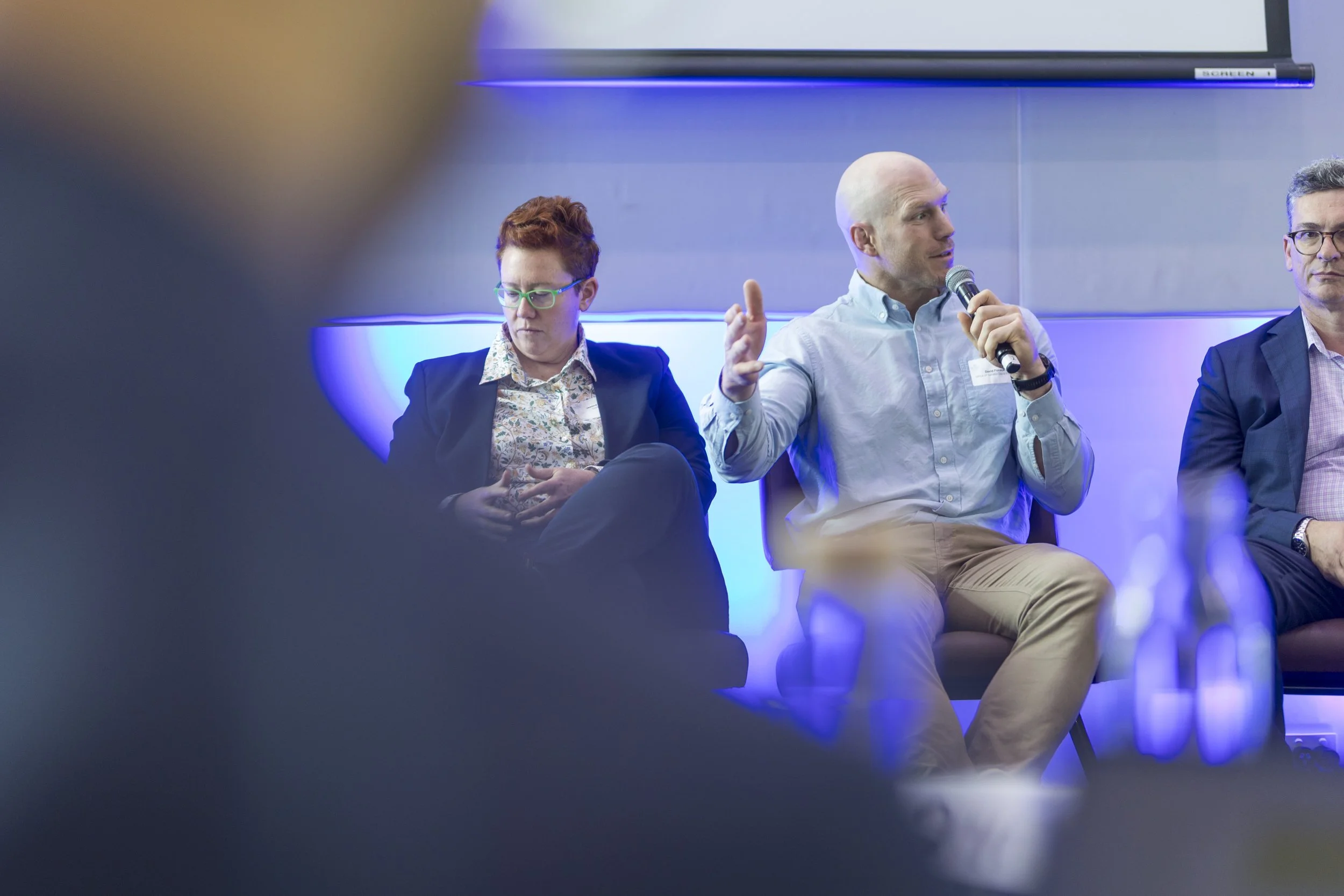 Moody, shallow depth of field moment of David Pocock on a housing summit panel discussion