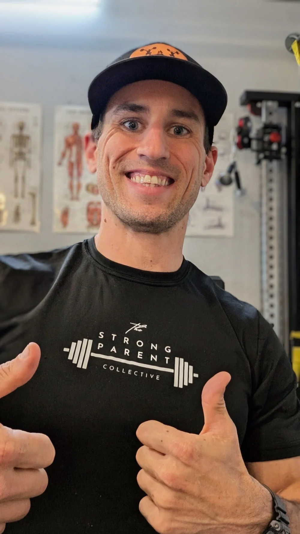 Personal trainer Sam Moses smiling and giving two thumbs up in the Tribe Fitness studio in Mead, CO