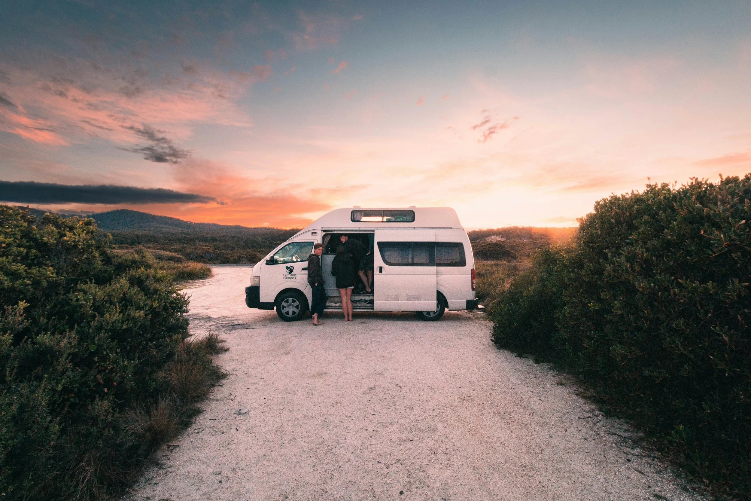 Viajeros con una van en Australia al atardecer