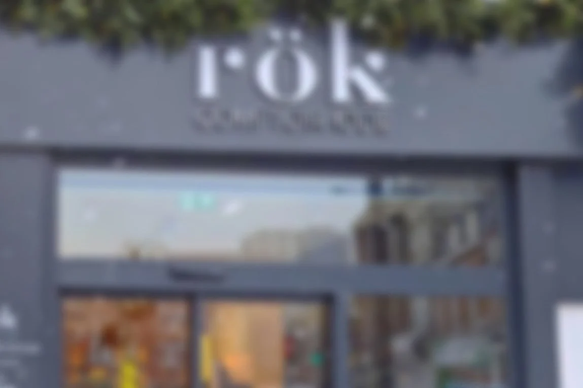 Panneau indiquant 'TOR QUINQUET' au-dessus d'une porte en verre.