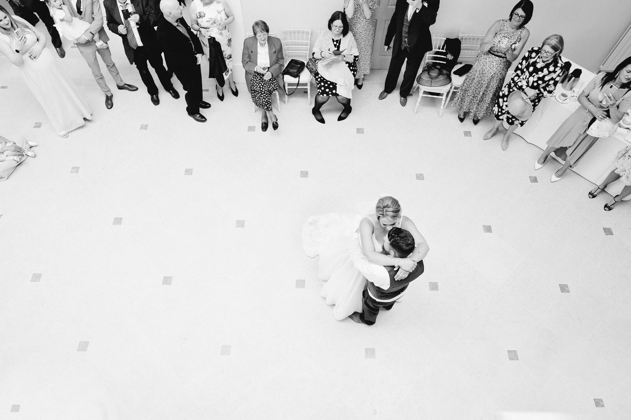 Looking down from above, a couple dance with their guests surrounding them