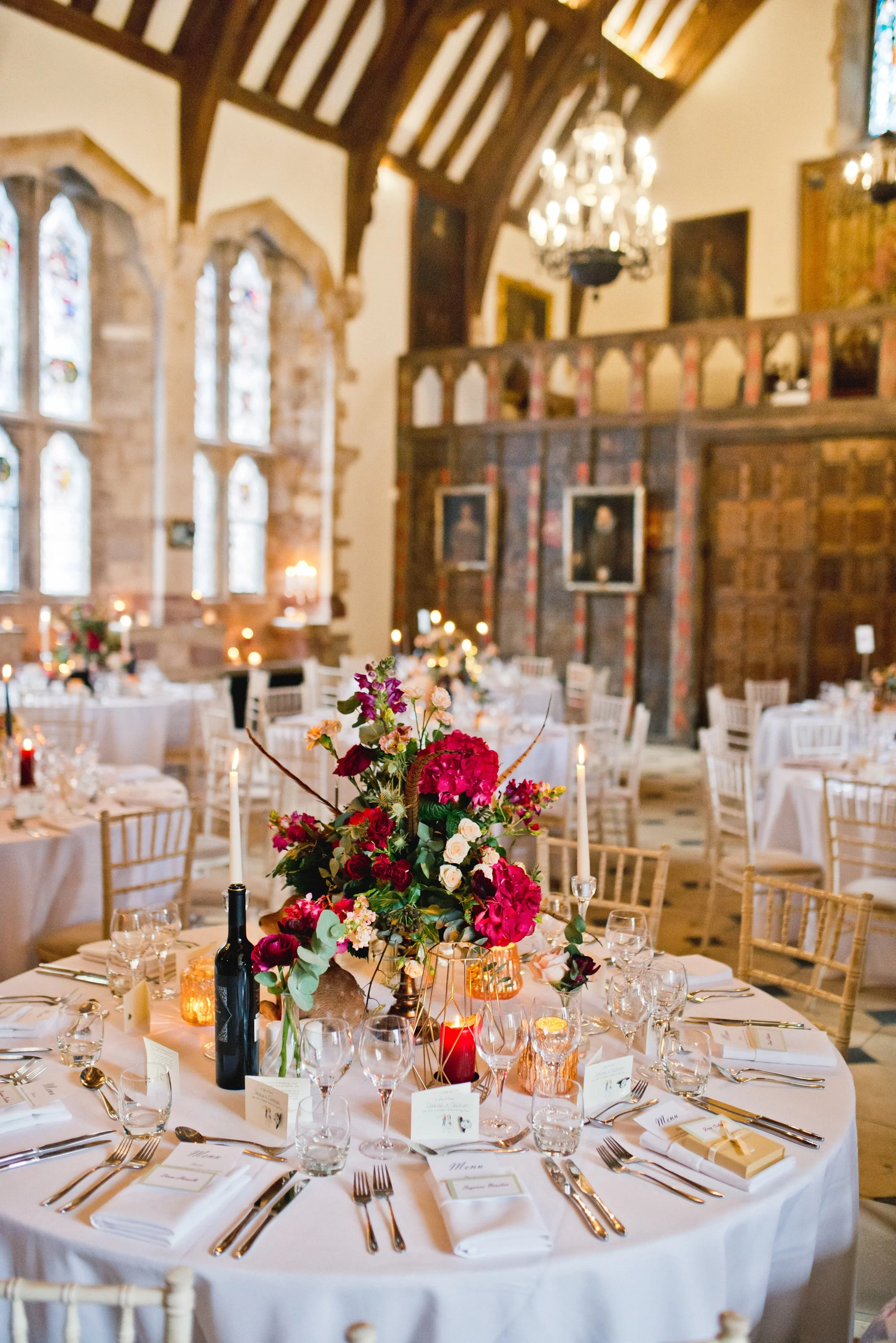 Wedding table decor, red hydrangea centre piece in a castle hall setting