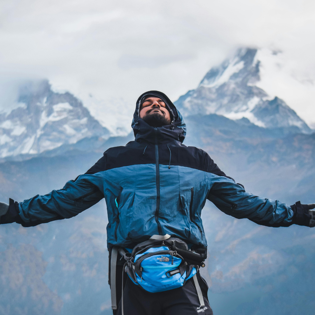 Image of a man at the top of a mountain outside representing Anxiety Therapy Orlando
