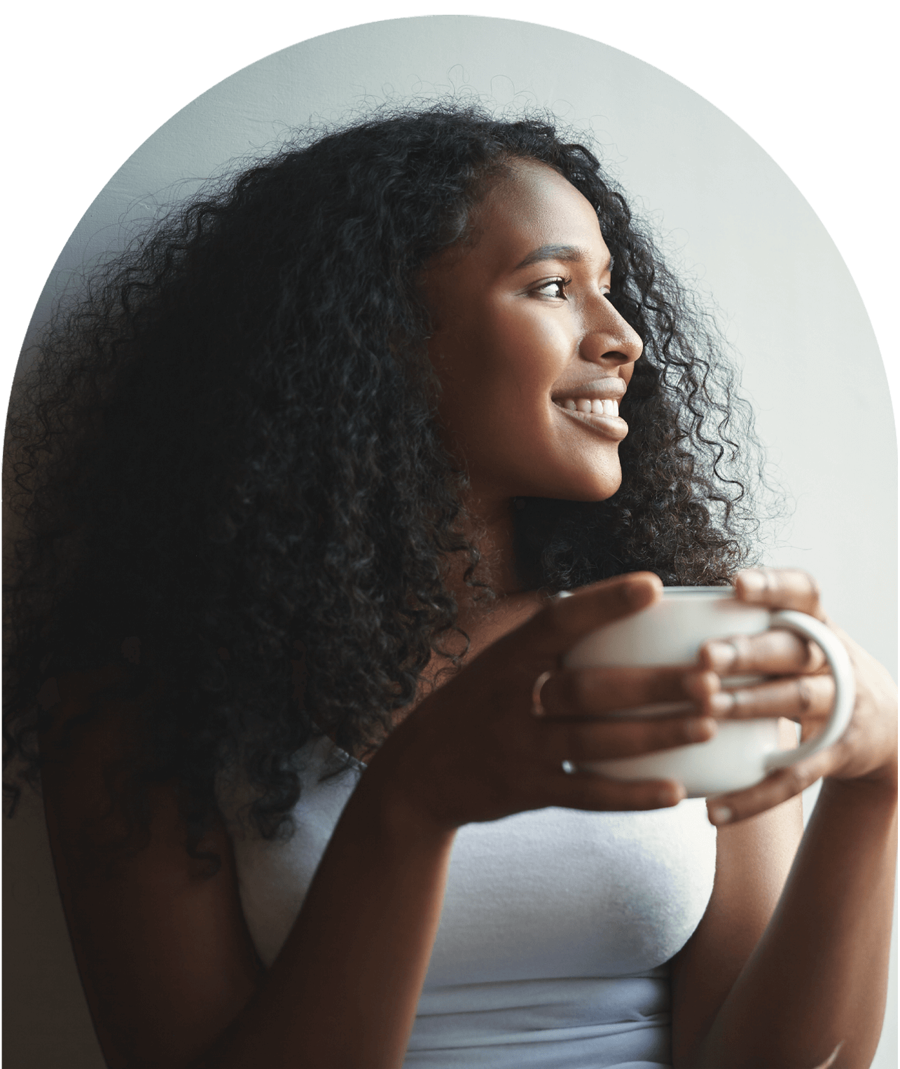 Smiling woman with curly hair holding a coffee mug, feeling calm after therapy in Orlando