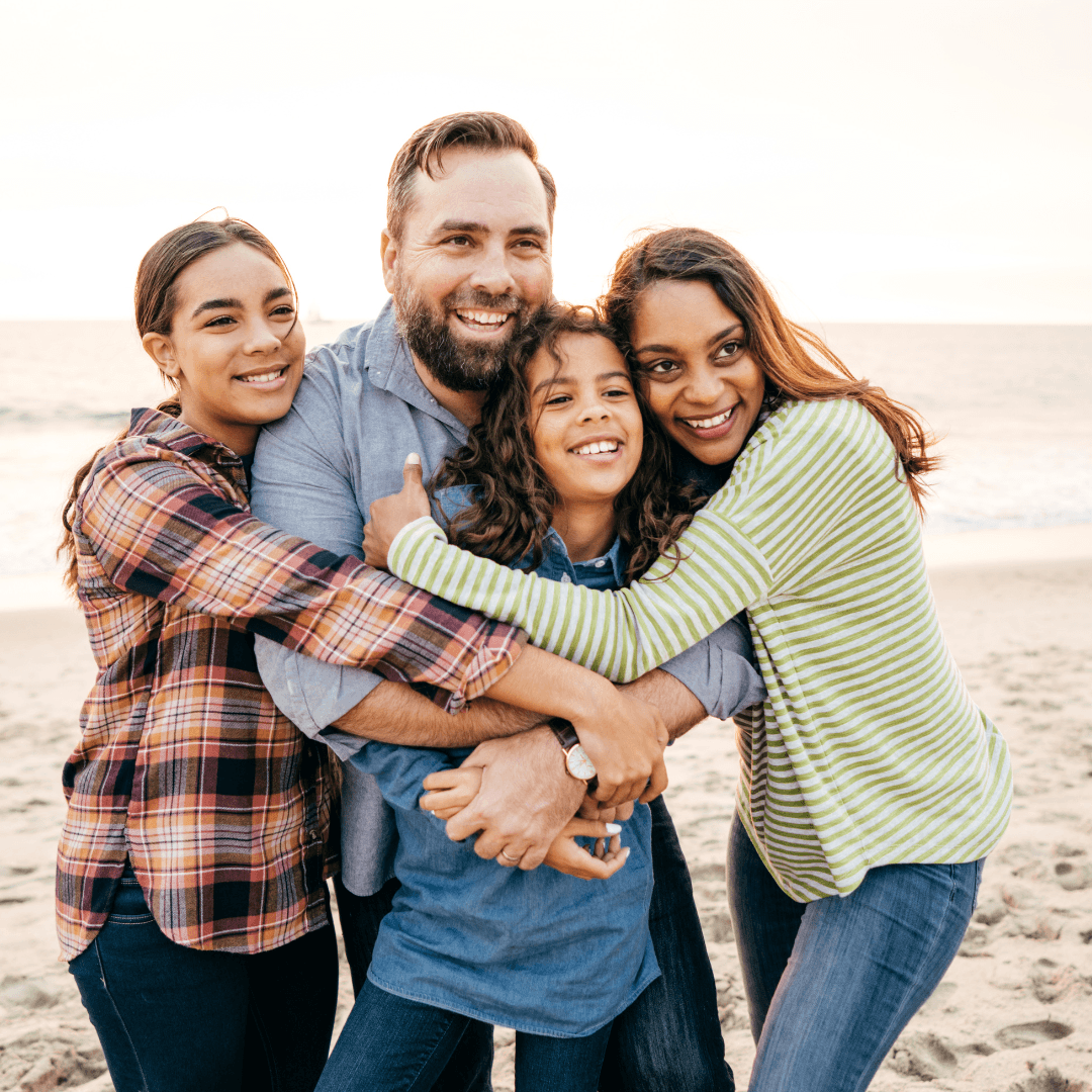 Image of kids with parents hugging on the beach representing parenting therapy