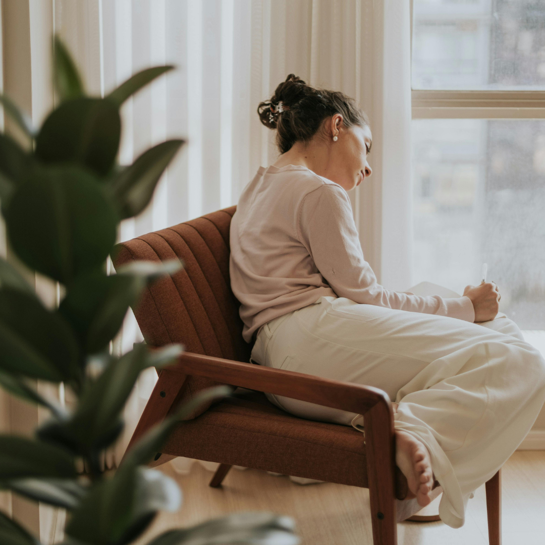 Image of a girl thinking on her chair representing Anxiety Therapy Orlando