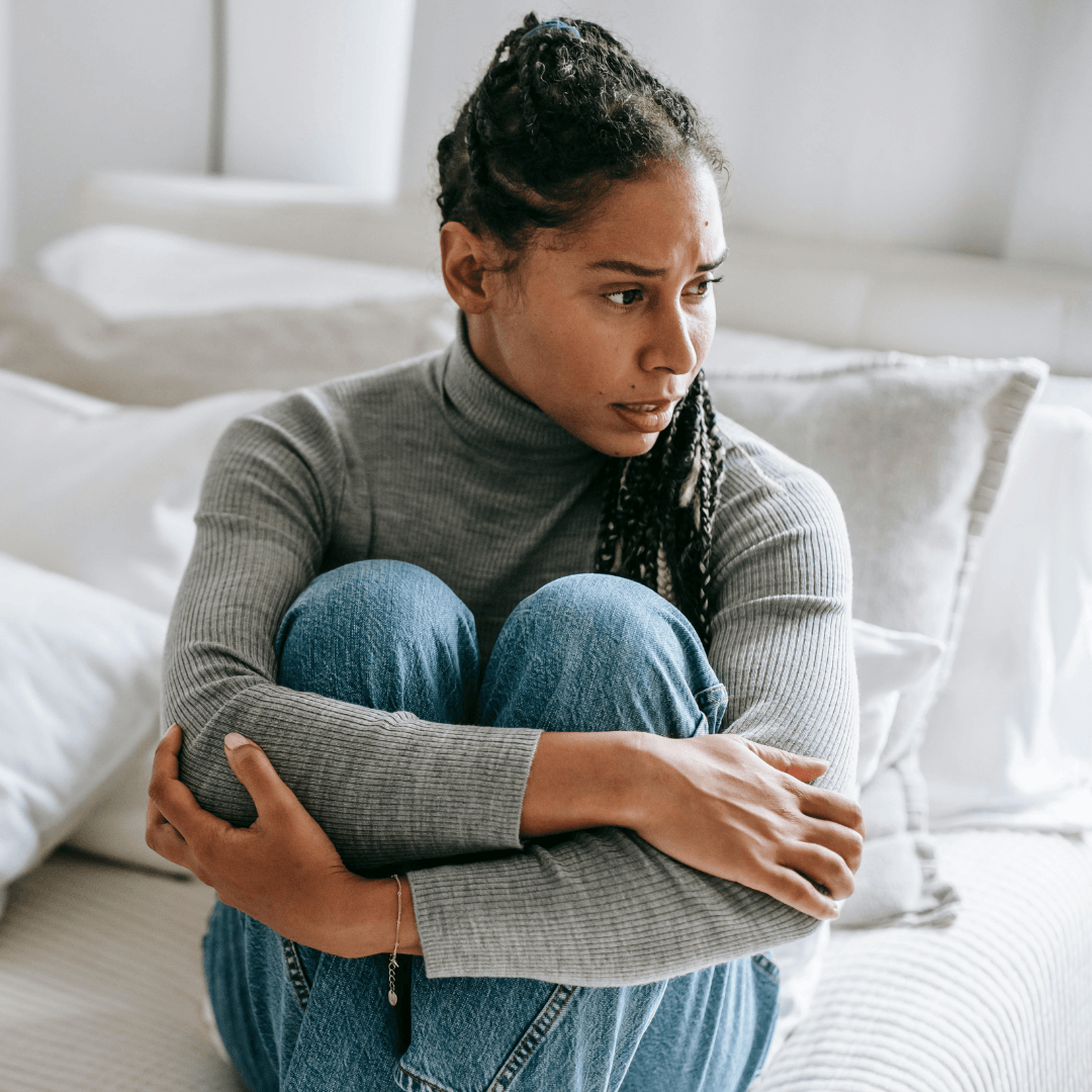 Image of a girl hugging her knees feeling worried representing anxiety therapy
