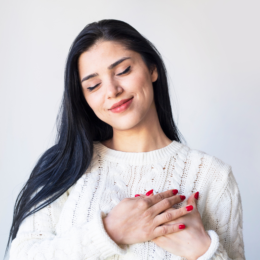 image of a girl touching her heart representing self compassion